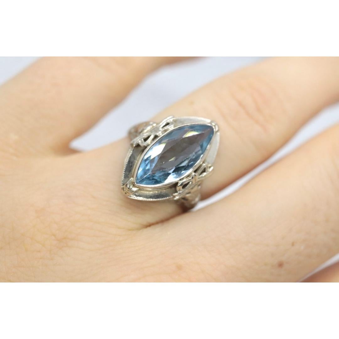 Vintage from the 1920s
Size: 5 1/4 US
Materials: Gold
Gemstone: Topaz
Gem color: Blue
Band Color: White

Style: Art Deco

Super unique vintage ring. Light Blue topaz set into 14k white gold ring. The band tapers into a filigree crown. The crown is