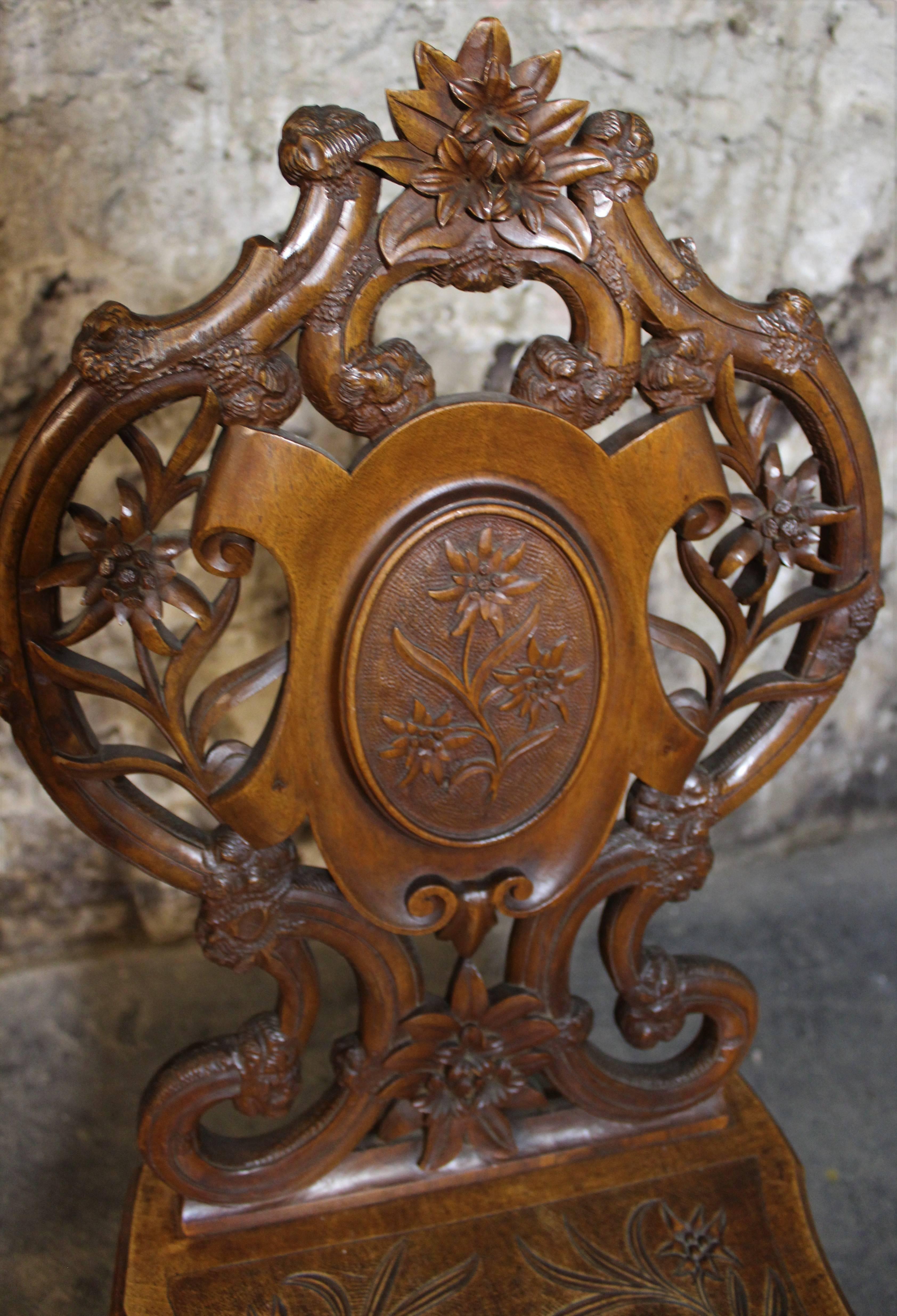 Swiss Brienz carved and marquetry walnut musical chair. Wind up mechanism and has a hinged seat that plays Edelweiss when sat on.