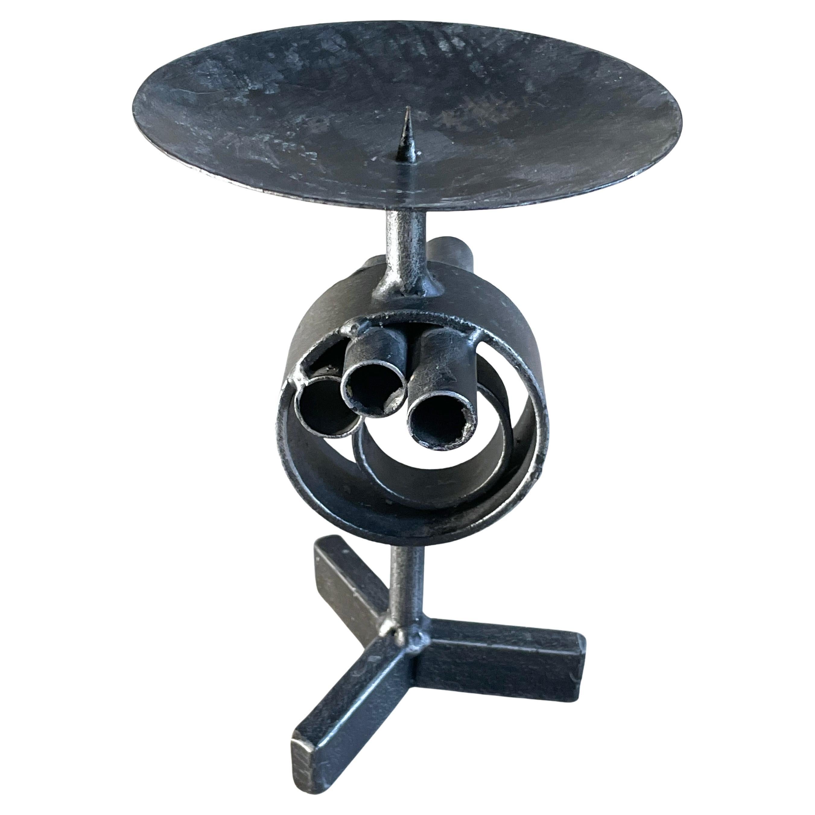 Brutalist floor standing welded metal candle holder dating from the 1960's. Believed to be of Swiss origin. In the style of Jean Tinguely With single candle holder on a tripod base.
Height: 90cm / Width: 30cm / Depth: 30cm