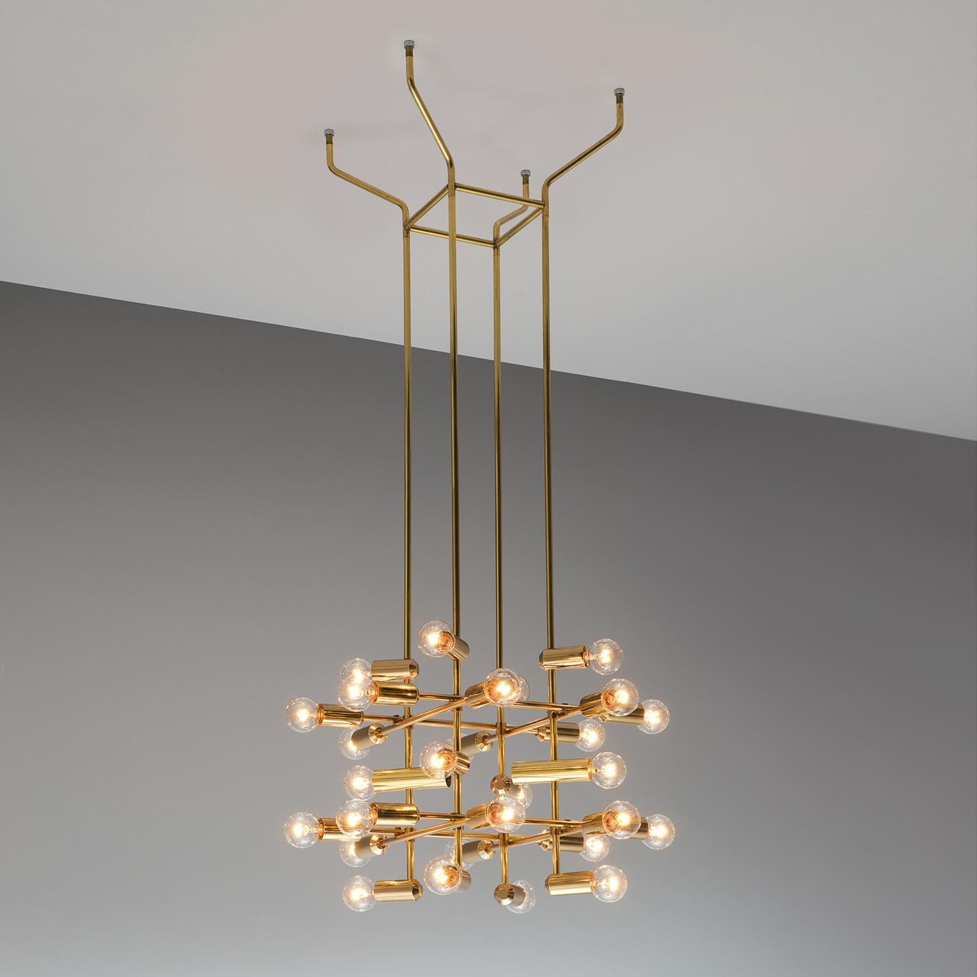 Chandelier in brass, Switzerland, 1960s.

This delicate chandelier is Minimalist yet warm. Each light consists of 28 light bulbs that are placed on the ends of brass horizontal beam. The beams form a cross-like pattern that is attached to the