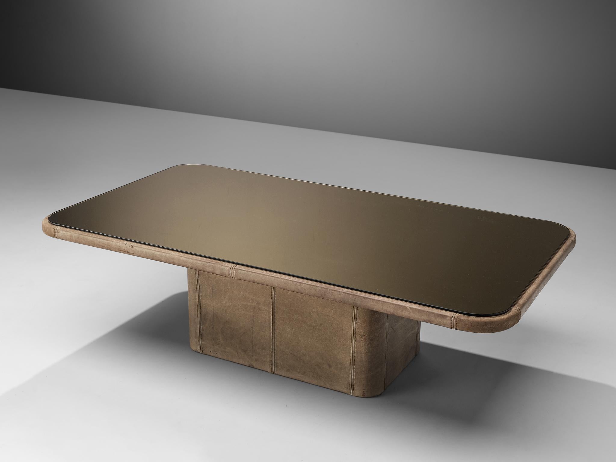 Attributed to De Sede, coffee table, leather, smoked glass, Switzerland, 1970s.

This robust and rectangular cocktail table is designed in the style of De Sede in the 1970s. The table is completely covered in grey leather and a smoked glass top.
