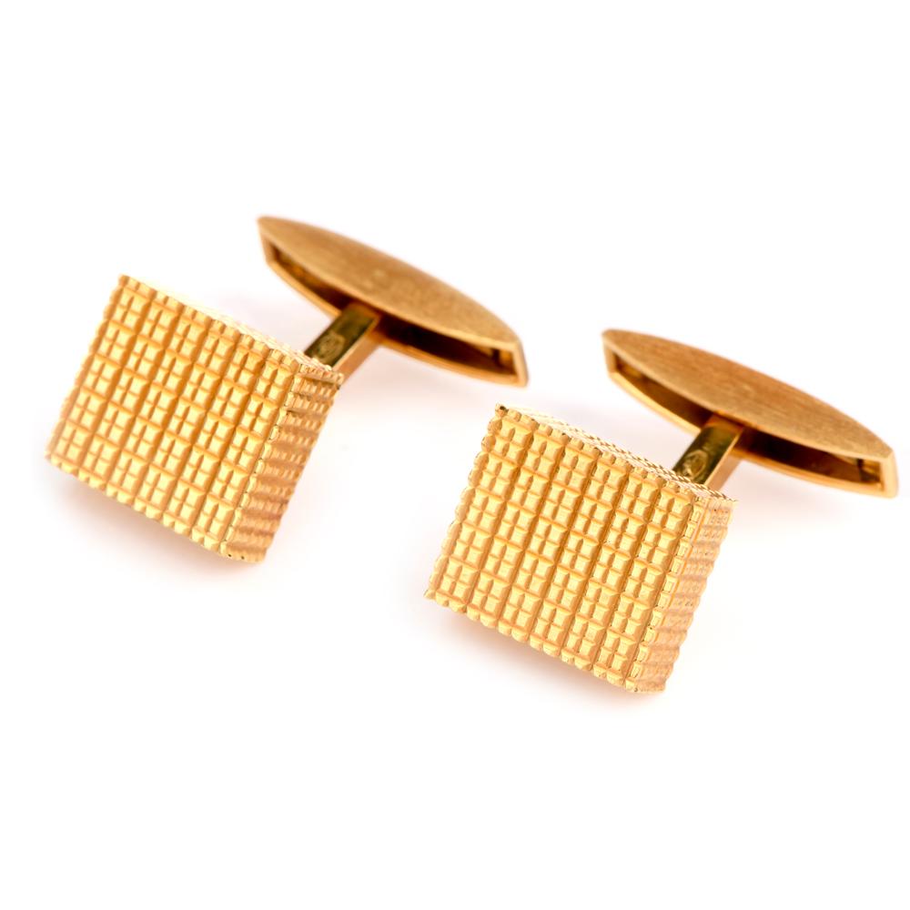 These sophisticated cufflinks are crafted in solid 18-karat yellow gold, weighing 17.6 grams and measuring 14mm x 12mm. Designed as textured cubes with a rigid linear design. Stamped with purity mark and ‘Swiss’ hallmark. In excellent