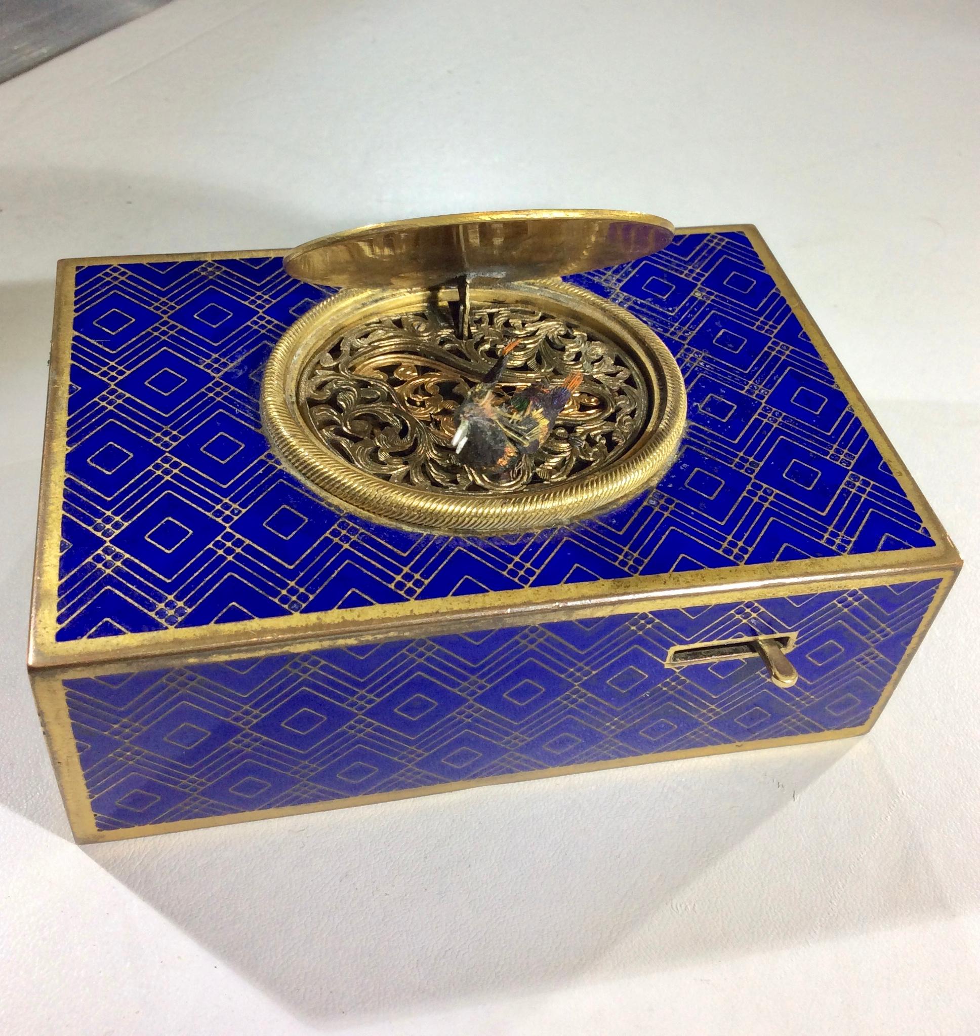 A bronze Swiss blue enamel automation bird singing box. The bird has beautiful multicolored plumage and when wound it moves its beak, flaps both wings, bobs tailfeather and turns entire body from side-to-side to the perfectly continuous synchronized