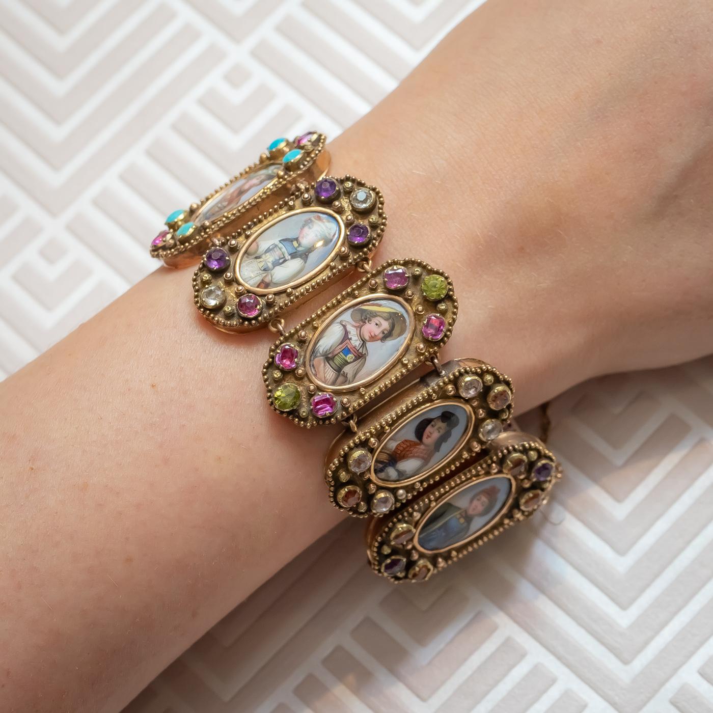 An antique, Swiss Cantons bracelet, with the Cantons represented by portraits of ladies in national costume, in painted enamel; set with rubies, turquoise, hessonite garnet, amethyst, aquamarine, rock crystal and peridot; mounted in gold. Each