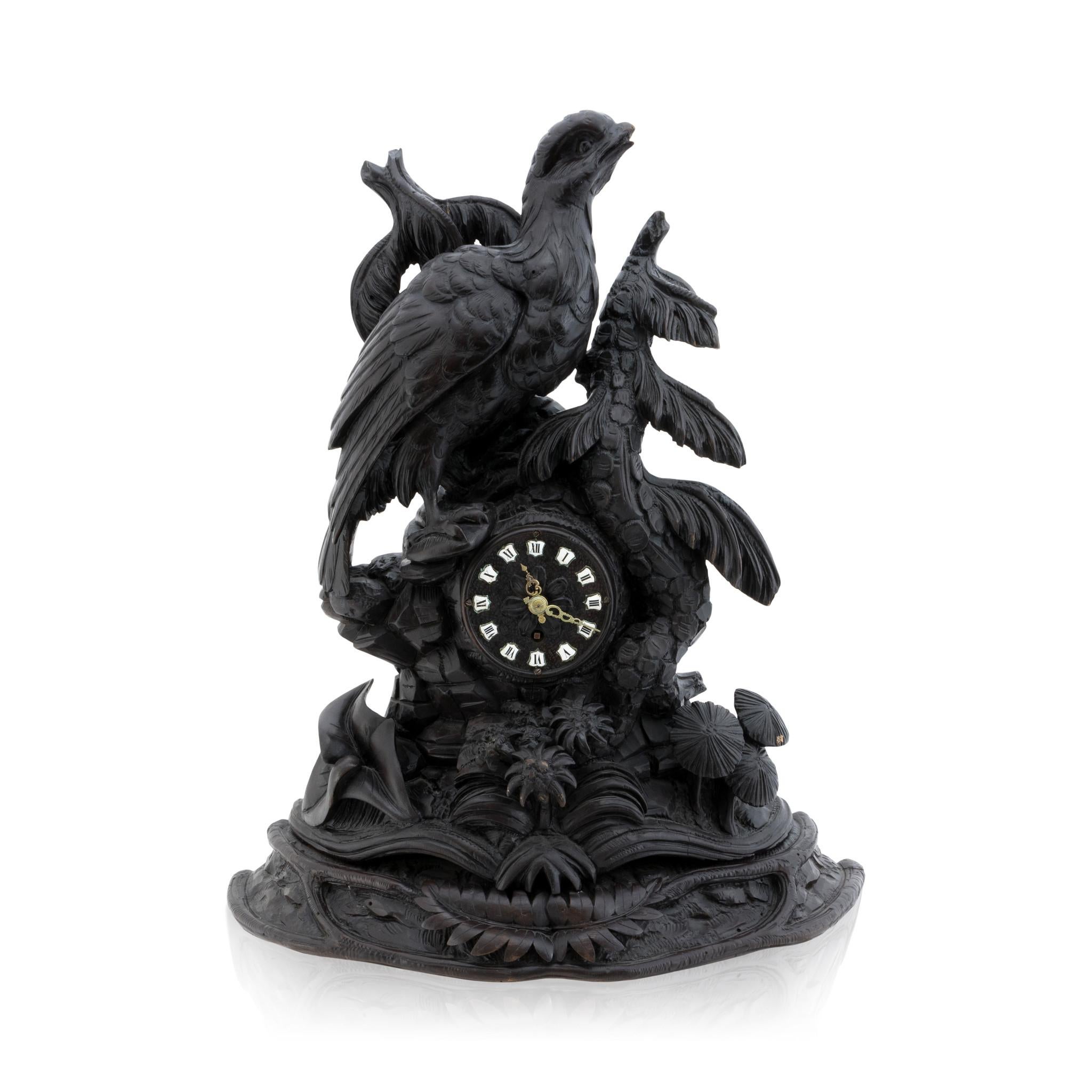 Horloge à gibier du 19e siècle, sculptée dans la forêt noire, avec un fleuron en forme de tétras. La gélinotte se repose sur un sol forestier détaillé avec de petits pins, du feuillage et des champignons. Whiting avec une tache très foncée et des
