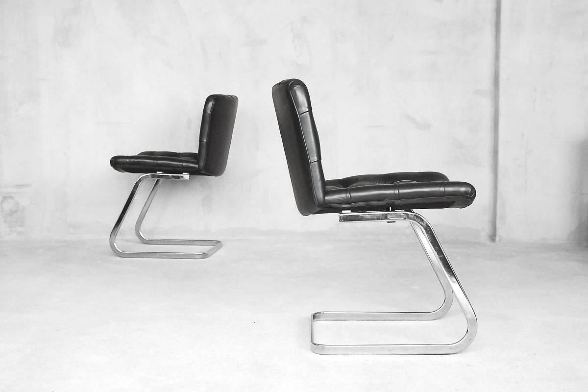 This set of two RH-304 chairs was designed by Robert Haussmann and manufactured in Switzerland by De Sede. This set is hand built in the 1960s, these pieces are upholstered in thick black buffalo neck leather with superb stitch detail and buttons.