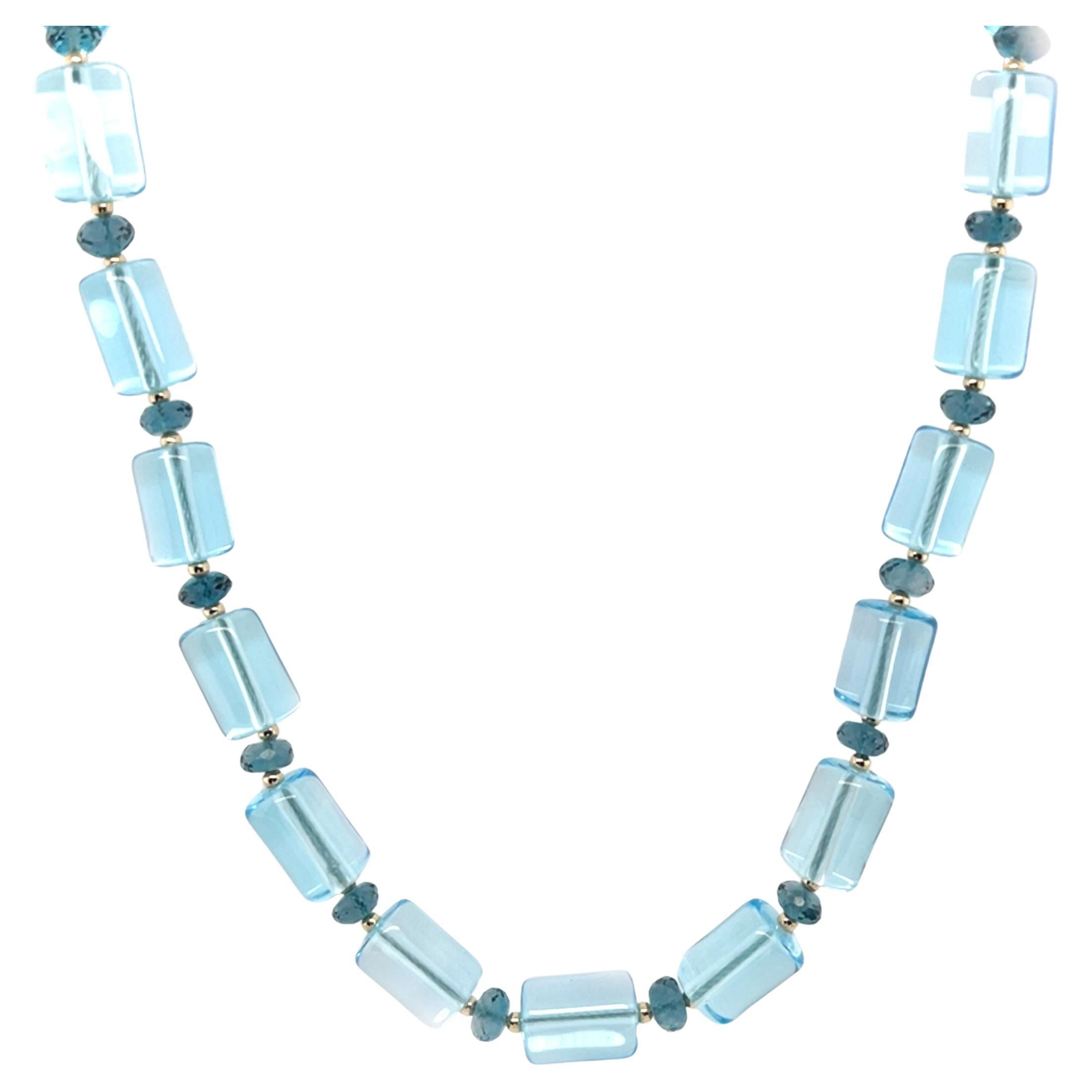 This beautifully attractive blue topaz necklace features bright Swiss blue topaz tubular beads paired with rich faceted London Blue topaz and 14k yellow gold accents. The Swiss blue topaz beads have bright crystal blue color and measure 7/16