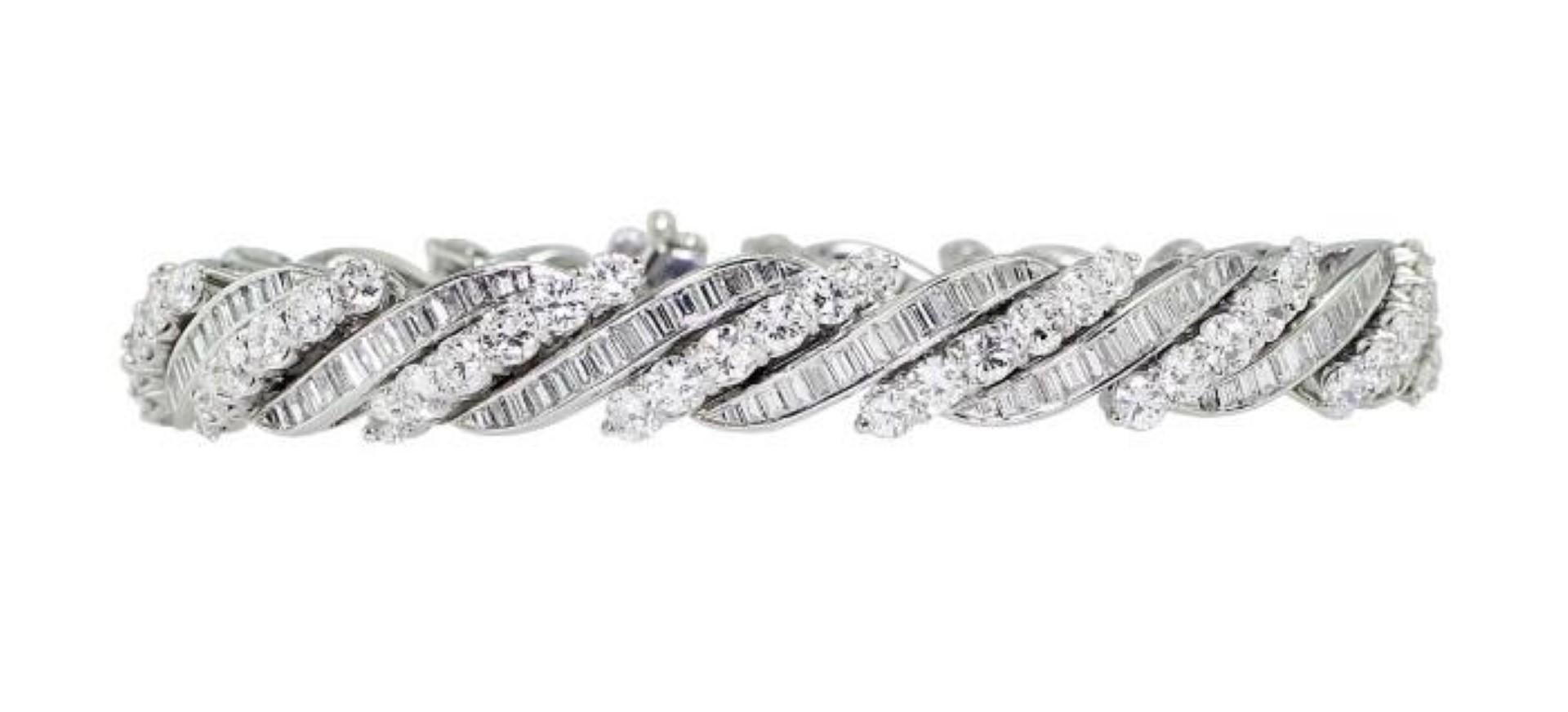 Gorgeous Swiss-made platinum bracelet set with 196 baguette cut diamonds and 84 round cut diamonds weighing a total of approximately 14.96cttw. Perfect craftmanship visible in the seamless clasp.