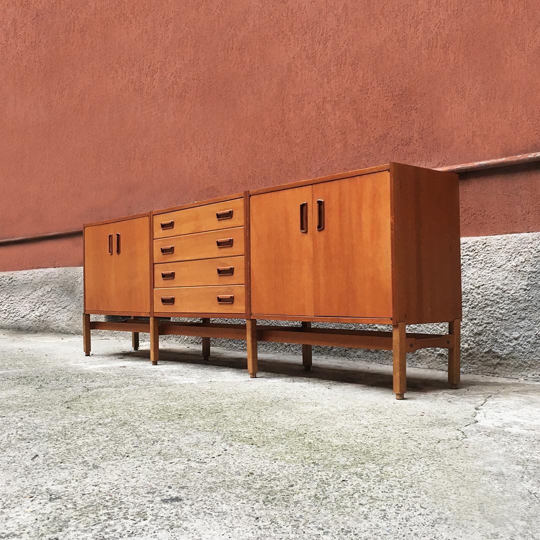 Swiss Mid-Century Modern modular blond teak sideboard, 1960s
Sideboard in blond teak of Swiss origin, consisting of a single base structure and three 80cm modules, two of which with hinged doors and circa 1960.

Very good