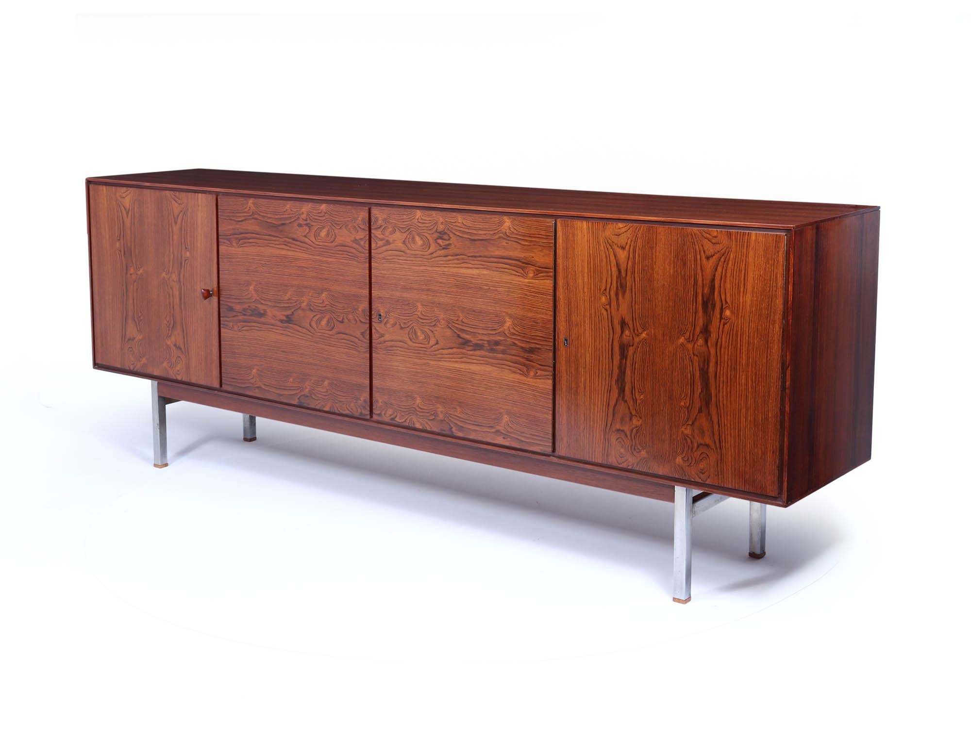 Mid Century Sideboard c1960 
A stunning piece of mid-century craftsmanship with this rare sideboard, meticulously produced from Honduras rosewood by Swiss manufacturers in the 1960s. Its striking contrasting grain highlights the natural beauty of