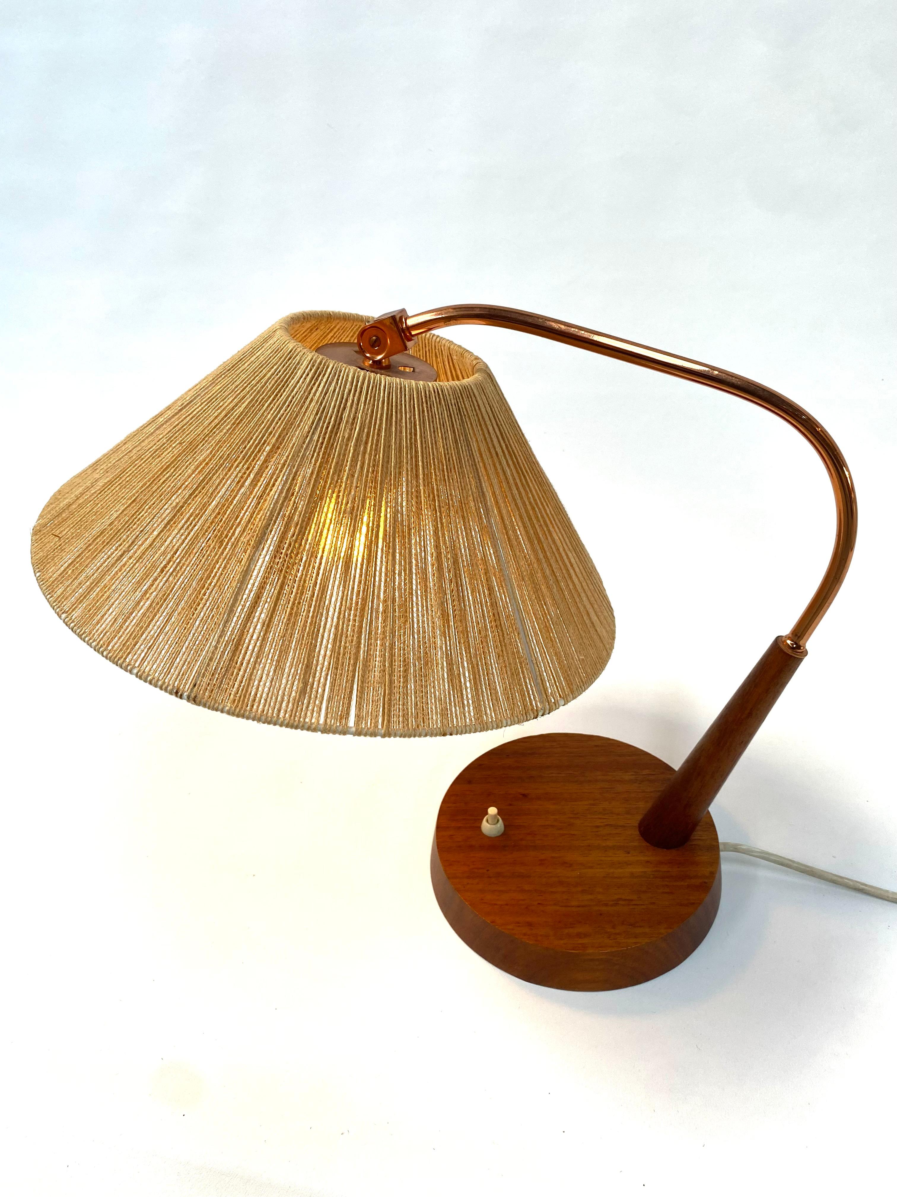 A stunnishing Danish table lamp made of teak, brass and sisal. Designed and manufactured in Switzerland by Temde Leuchten in the sixtiesby Temde in Switzerland. The sisal lampshade in combination with a E27 (US E26) light bulb creates a beautyfull