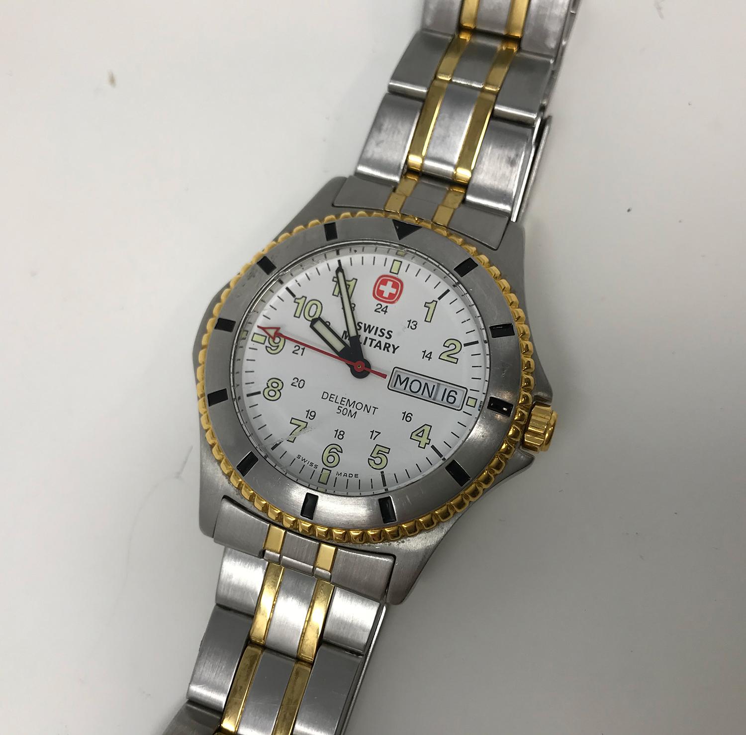Swiss Military Delemont quartz movement stainless steel watch, Swiss-made 0960627. The watch is water resistant up to 50m. Analog dial with a case size of 39mm. The watch will fit an 8-8 1/2-inch wrist and has a safety clip. In good working order,
