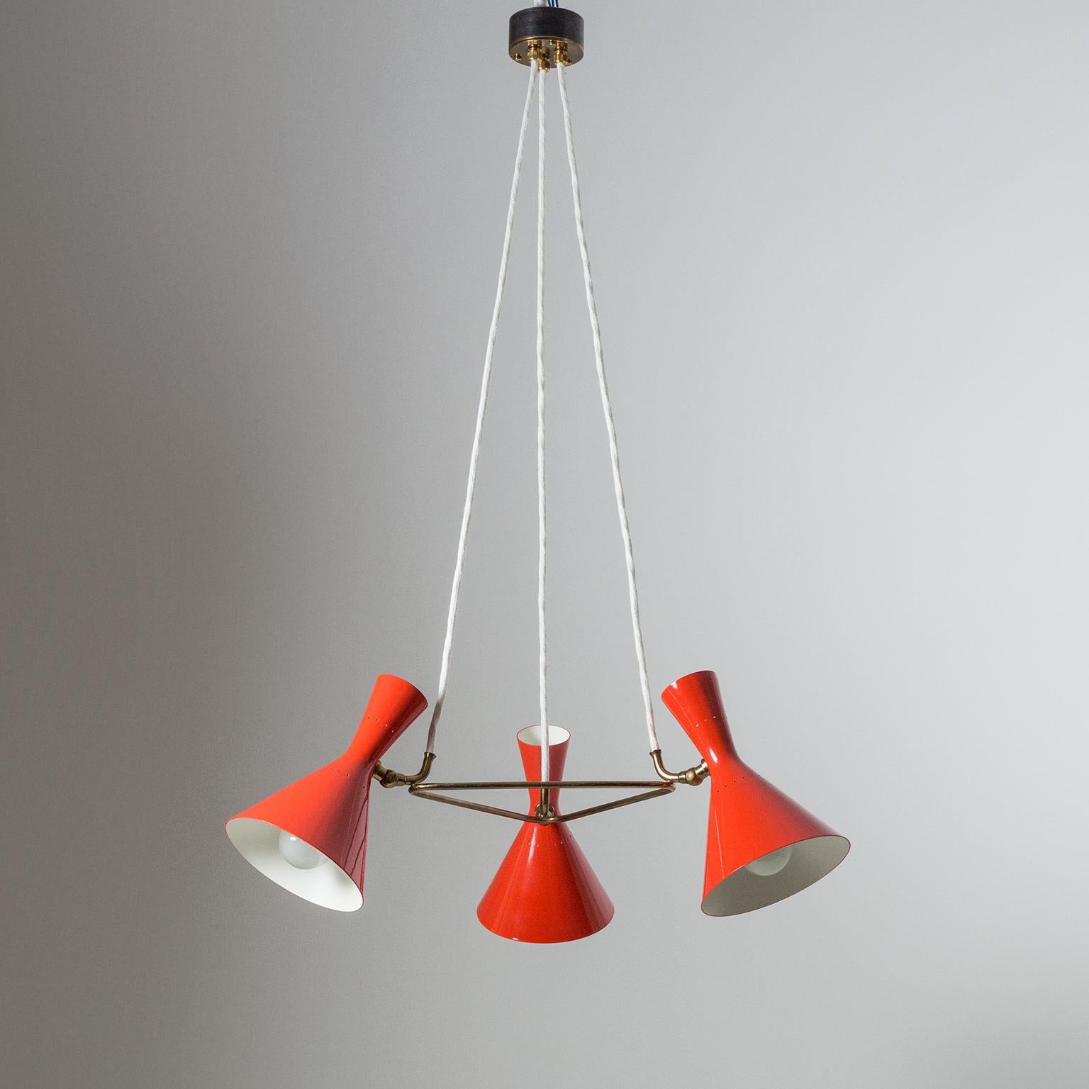 Joli lustre original en forme de cône des années 1950 par Baumann Kölliker qui a produit plusieurs modèles de haute qualité pour Stilnovo. Trois abat-jour rouge vif à double cône (