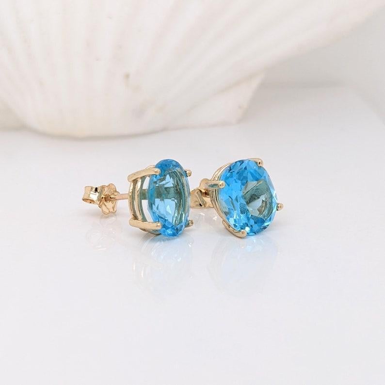 Bellissime borchie solitarie ovali in oro massiccio 14k. Il topazio blu svizzero in evidenza brilla in modo eccellente in questi orecchini a perno! La chiusura push back si blocca in modo sicuro per essere indossata tutto il giorno in modo facile e