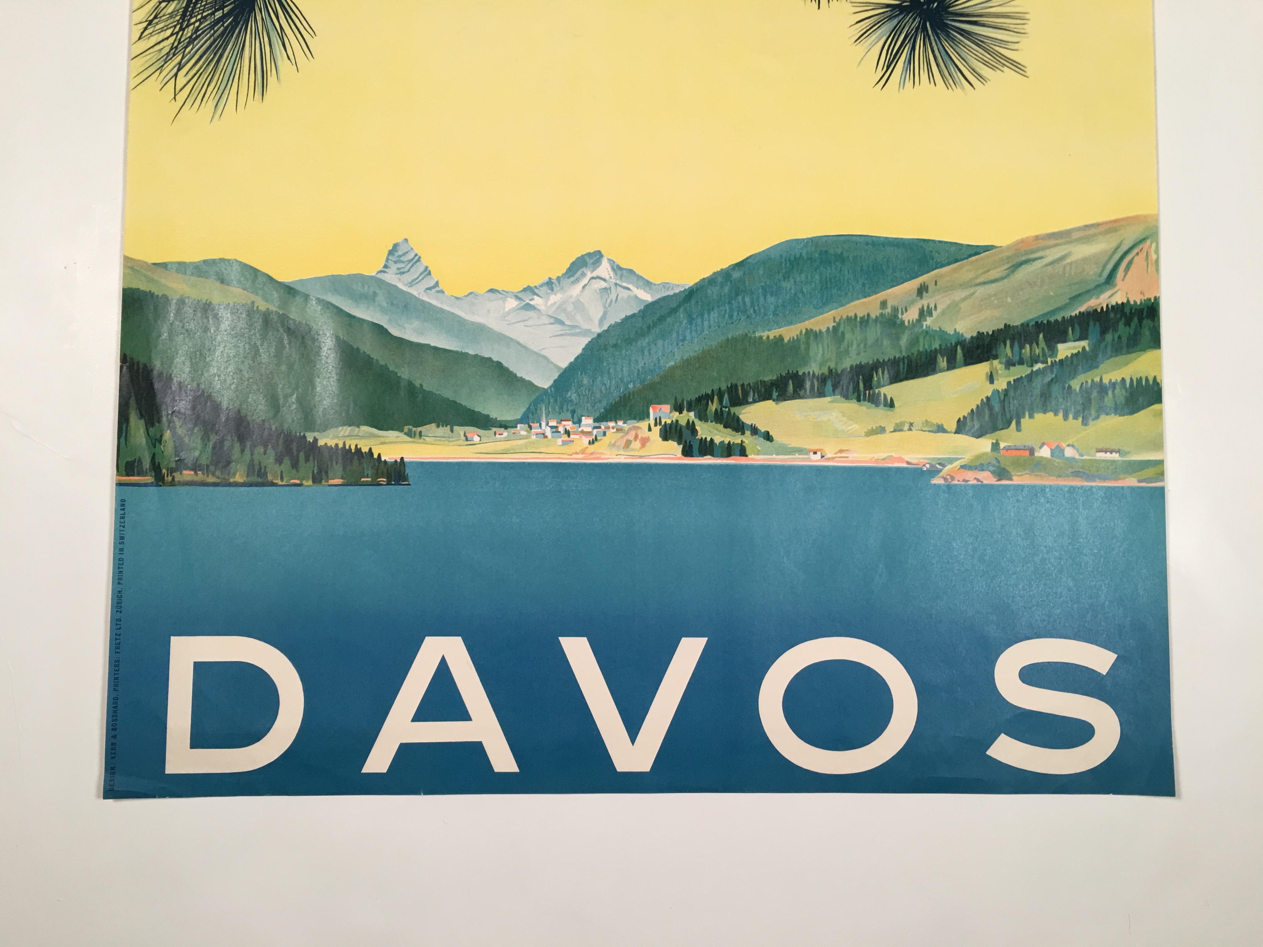 An original Swiss lithograph travel poster for Davos, designed by Kern and Bosshard, circa 1949, featuring a strikingly modern design, with the branches of a pine tree in the foreground against a beautifully colored sky, which goes from blue to