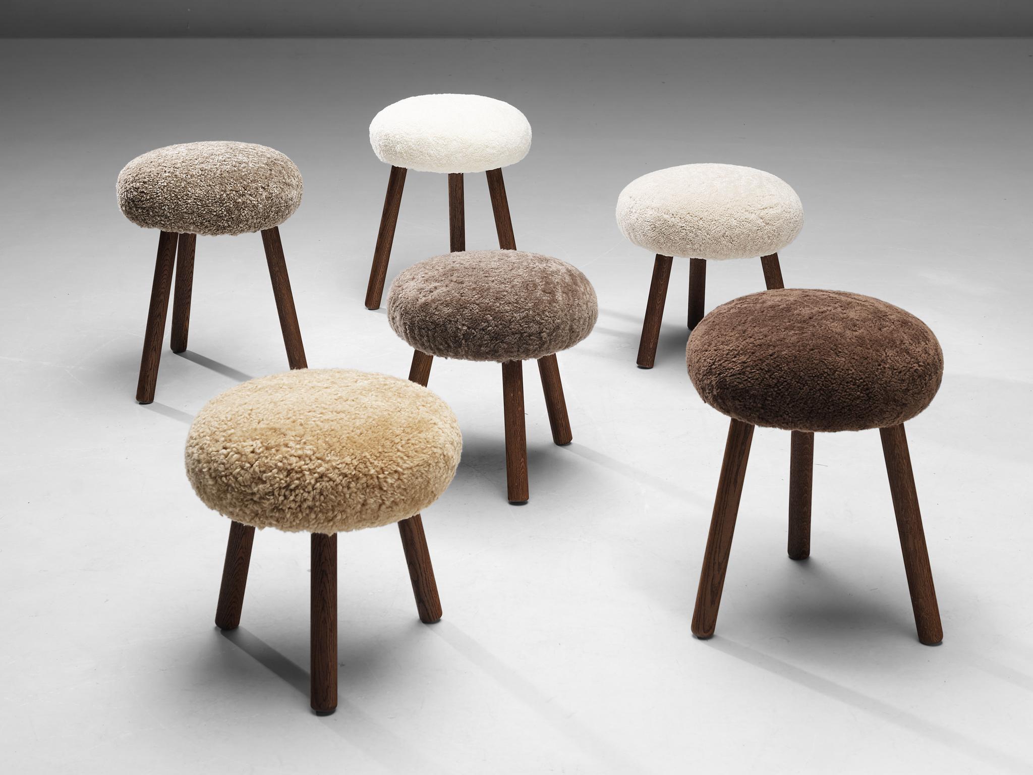 Tripod stools or side tables, solid oak, fabric, Switzerland, 1960s-1970s.

Beautiful crafted oak stools originating from the exhibition center in St. Gallen, Switzerland. The seats are reupholstered in a soft shearling fabric that ranges in color