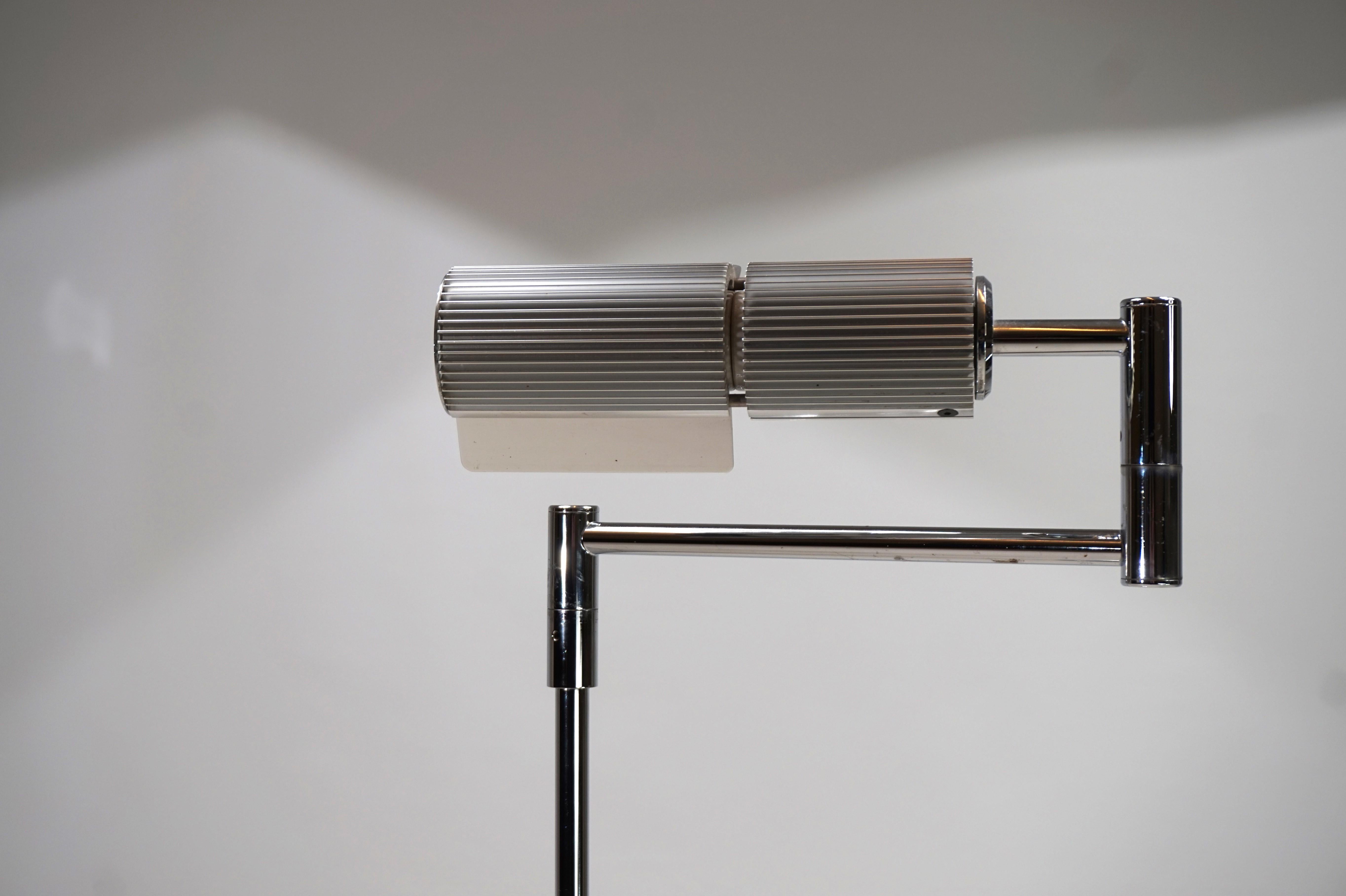 This classic floor lamp from the Zurich manufacturer Swisslamps is in excellent condition. The lamp arm, which can be swiveled 360 degrees, rests on a heavy chrome-plated base that shows hardly any signs of wear. The finely ribbed lamp head at the