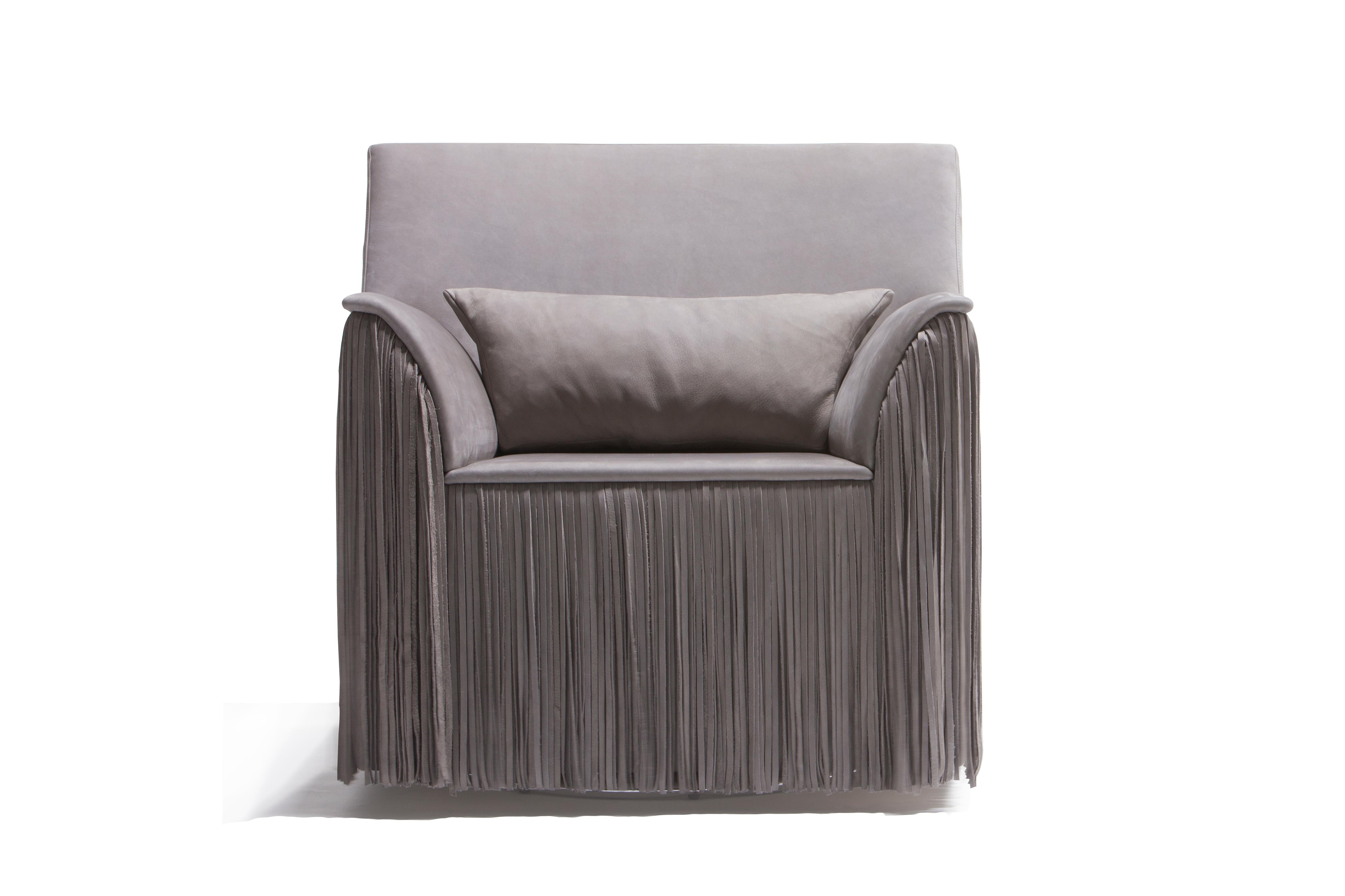 The TAGLIA swivel armchair introduces the timeless fashion element of leather fringes to haute furniture design. The swung armrest and the oversized backrest are surrounded by a dense skirt of nubuck leather fringes that come to life through a