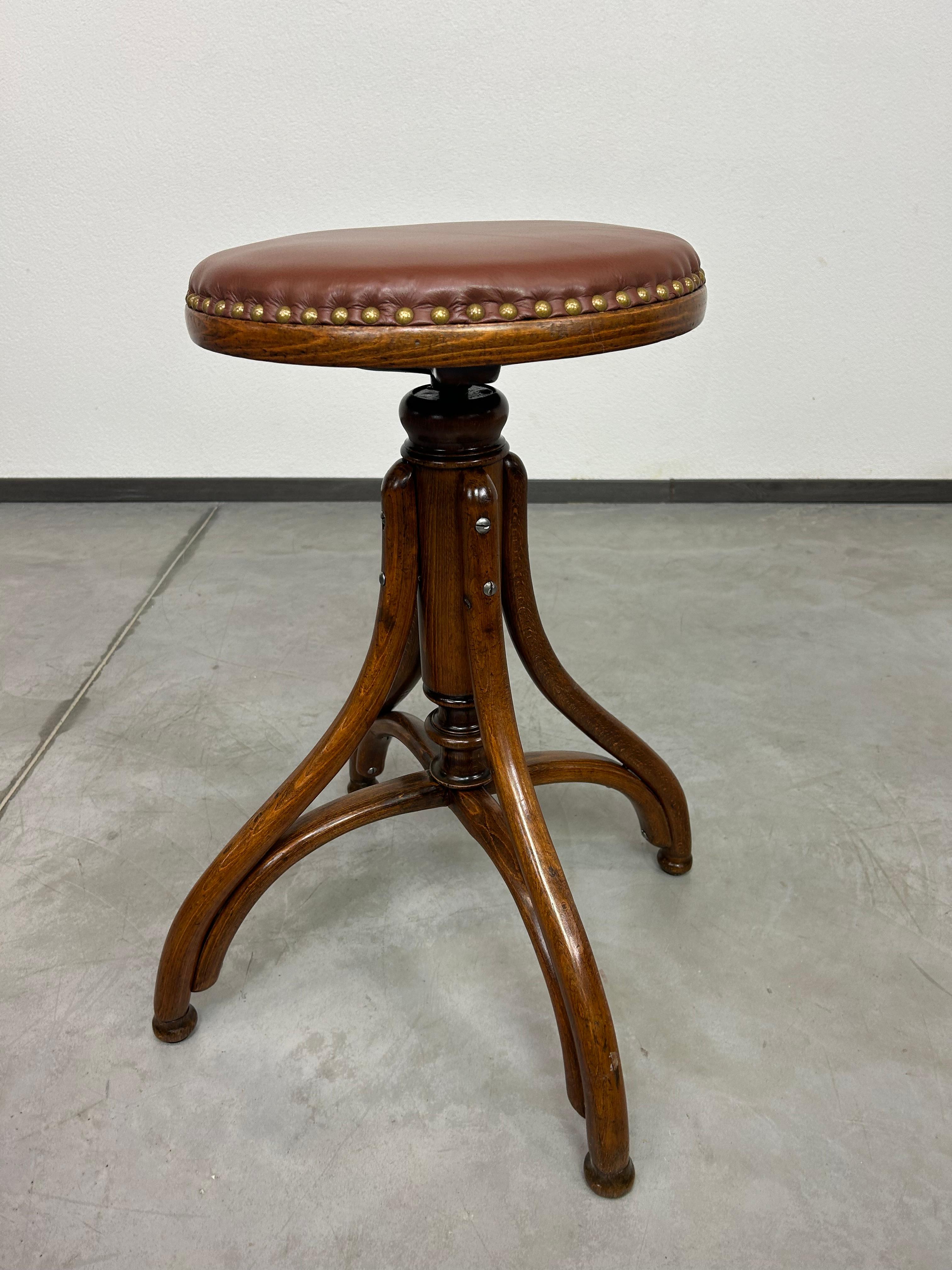 Tabouret de bar pivotant avec assise en cuir. Teinté et repoli par des professionnels.
