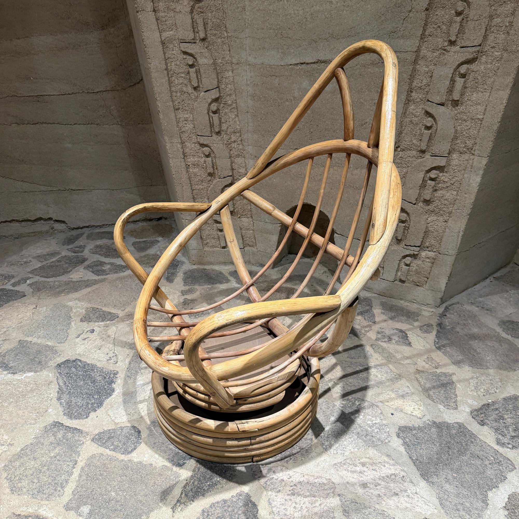 For your consideration, a swivel bucket lounge chair on stacked rattan bamboo pedestal base .Mid-Century period. USA circa the 1970s.

Dimensions: 42.5
