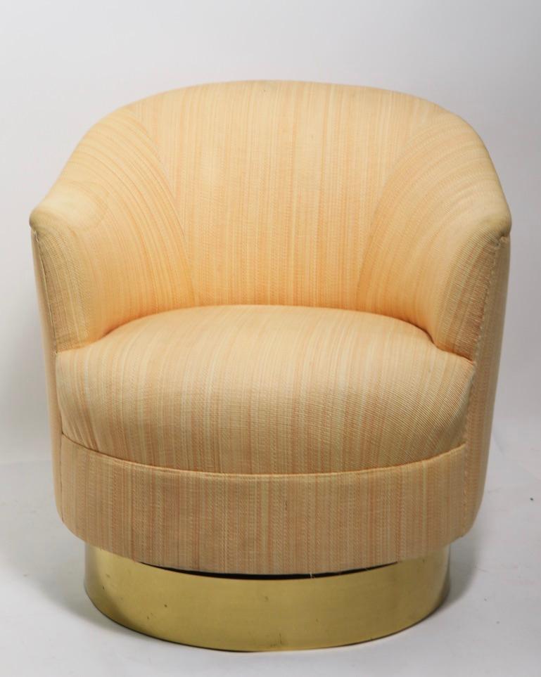 Swivel chair on gold tone plinth base, with matching over stuffed ottoman footrest, Very well crafted pieces, done in the Art Deco Revival, Hollywood Regency Style, solid and sturdy, upholstery shows some staining and wear. Attributed to Milo