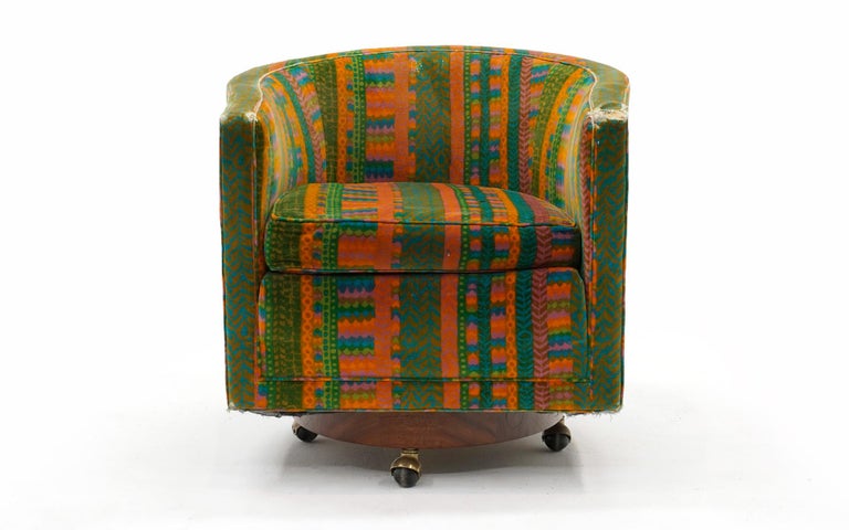 Dunbar barrel swivel lounge chair with a walnut base on brass casters. The casters can easily be removed if so desired. The walnut base has been expertly refinished and the mechanism works perfectly. The original Jack Lenor Larsen Fabric is amazing