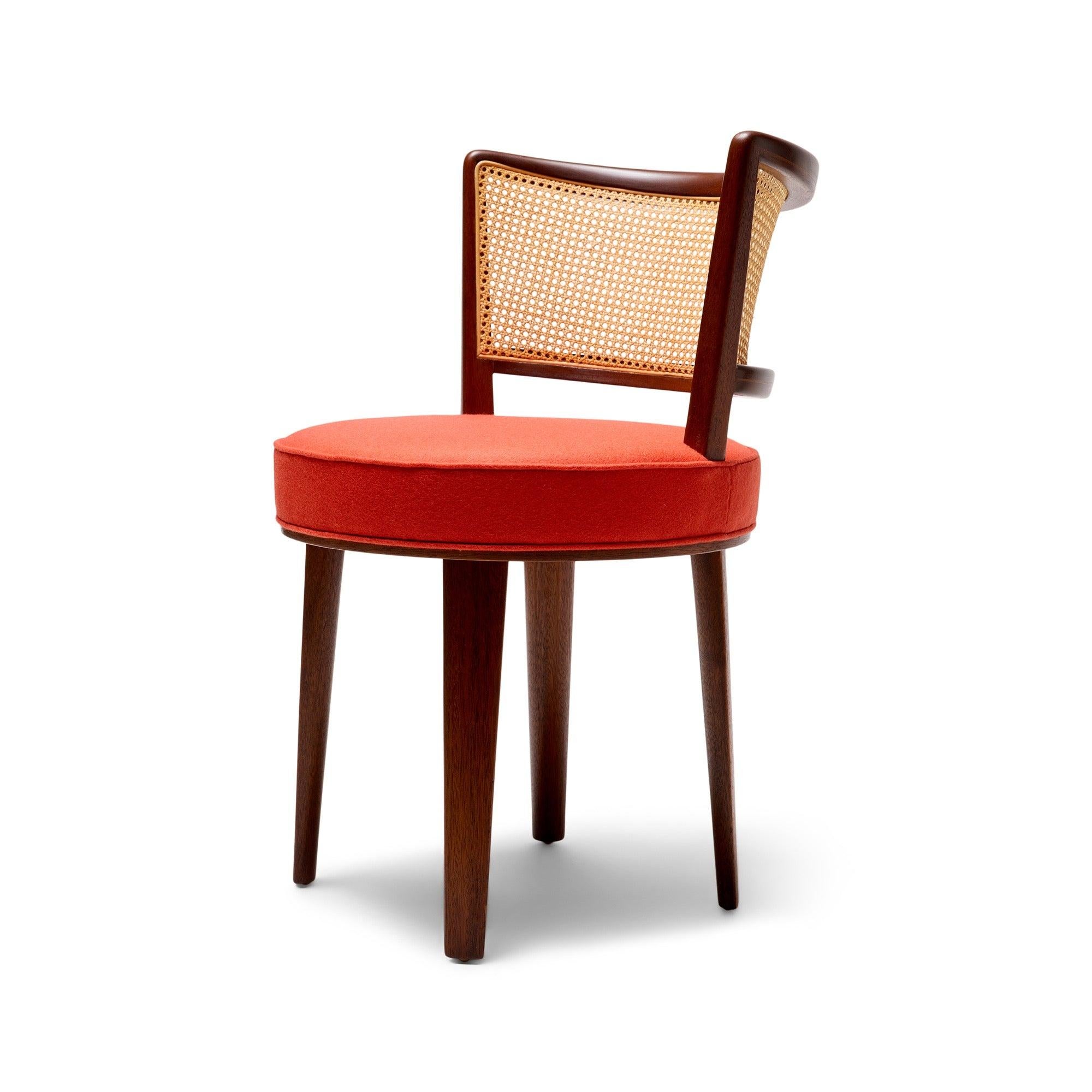 A mahogany swivel chair with caned back and a round seat.