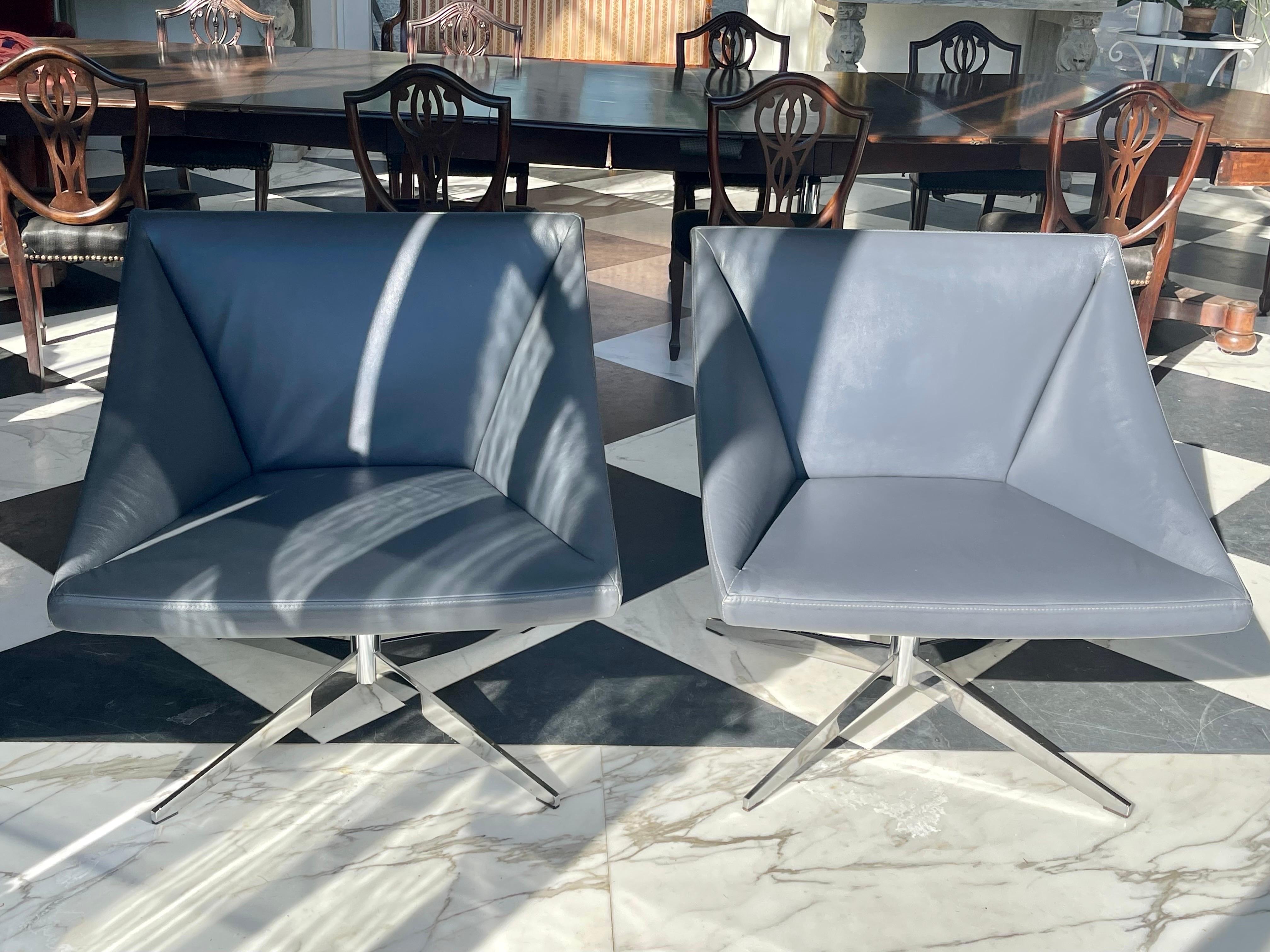 Paire de fauteuils pivotants de Davis Furniture, recouverts de cuir gris. Avec une base chromée en forme d'étoile. 
La coque extérieure est en plastique blanc. 
Davis Furniture Industries est une entreprise familiale américaine.