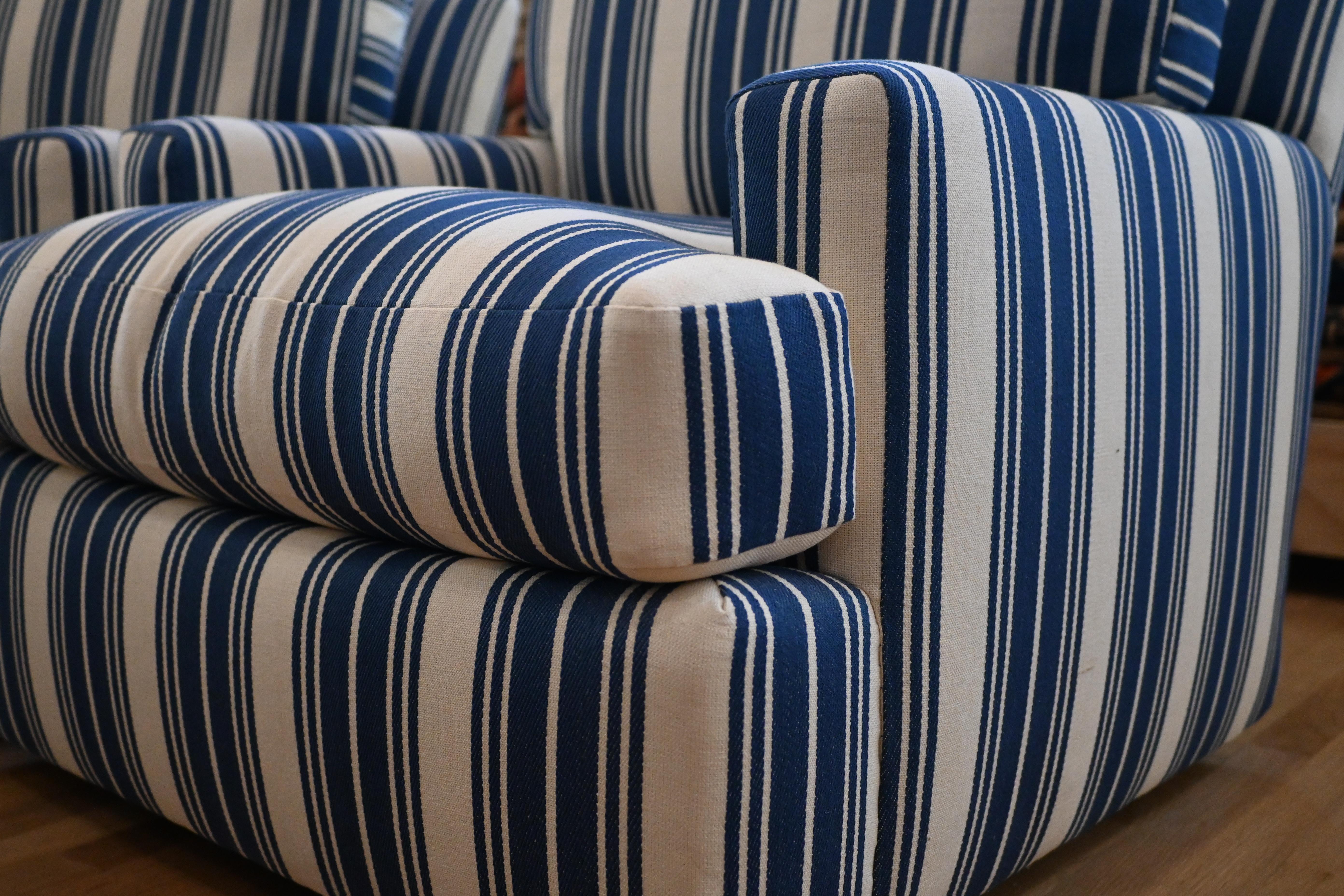 Questa coppia di grandi sedie girevoli da salotto è incredibilmente comoda e ben fatta. Recentemente è stato tappezzato con il tessuto House of Scalamandre in ticking blu di alta gamma. La base, il braccio e la forma sono notevoli e fanno di queste