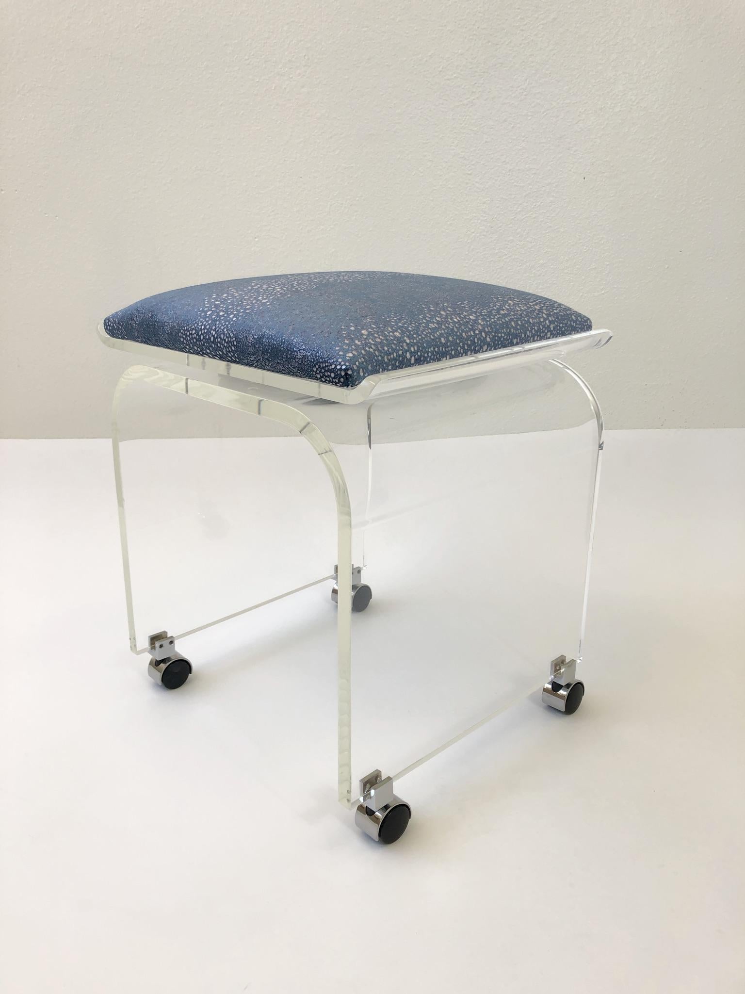 A glamorous swivel top, clear Lucite with chrome casters “Waterfall” vanity stool. Design by Charles Hollis Jones in the 1970s.
The stool has been newly professionally polished and recovered with a beautiful light blue velvet with a faux shagreen