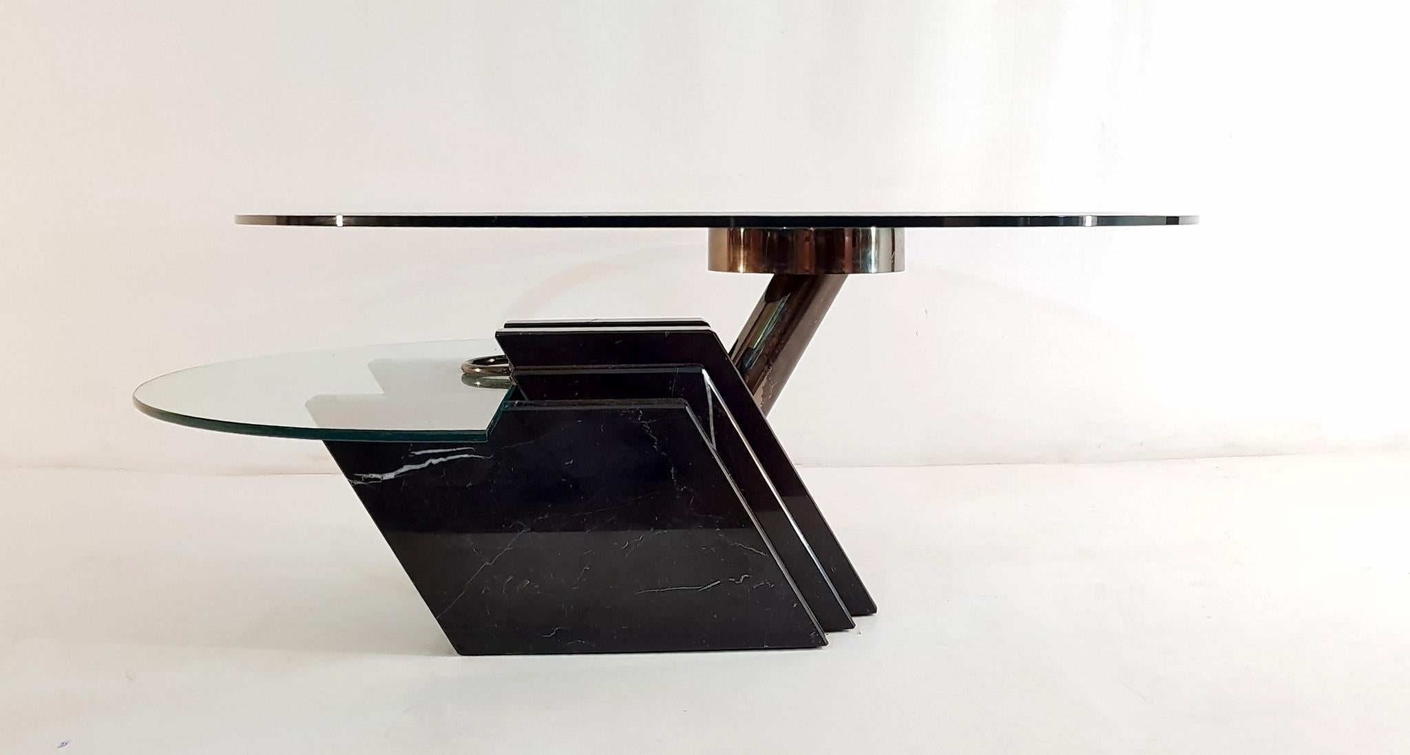 Excellent cocktail or coffee table in two levels with a round top that swivels and a half moon shaped second level resing on a massive geometric base in black Madagascar marble.