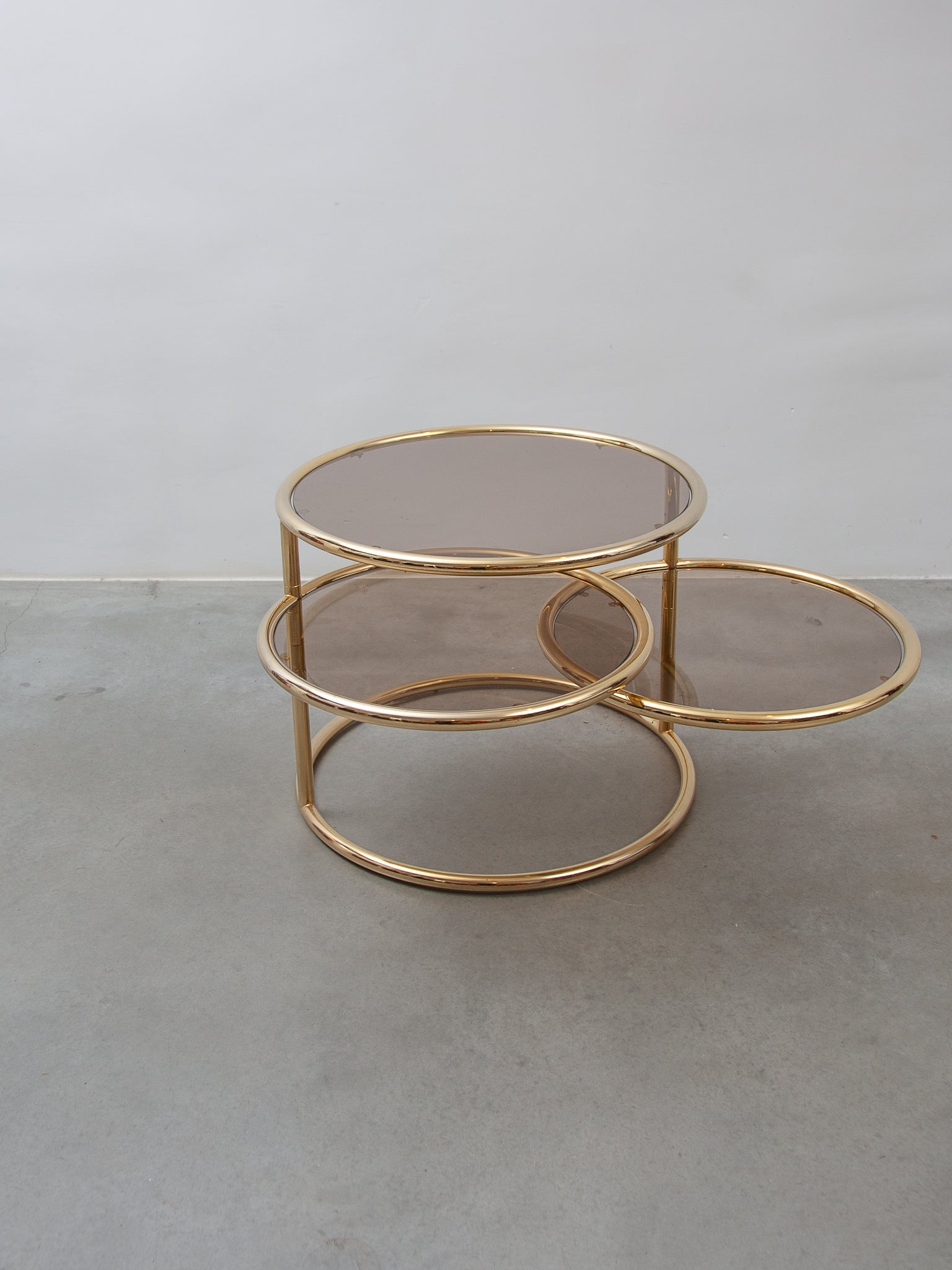 An Italian Mid-century modern 1970's, designed by Milo Baughman for Morex. Three tier fume round glass and brass tube coffee, cocktail-table. Two tiers swivel out to desired shape. In perfect condition.
Dimensions 52 cm Height, diameter bottom table