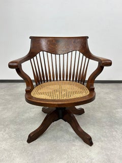 Swivel oak office chair with rattan seat