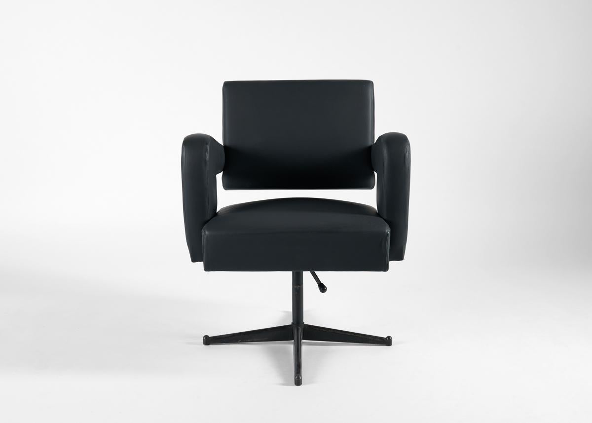 Una sedia da ufficio girevole rivestita in similpelle con quattro piedi a raggiera e braccioli sbarazzini. Ispirato al tardo Deco e al designer francese di metà secolo Jacques Adnet.

Con una carriera che abbraccia molti dei movimenti estetici