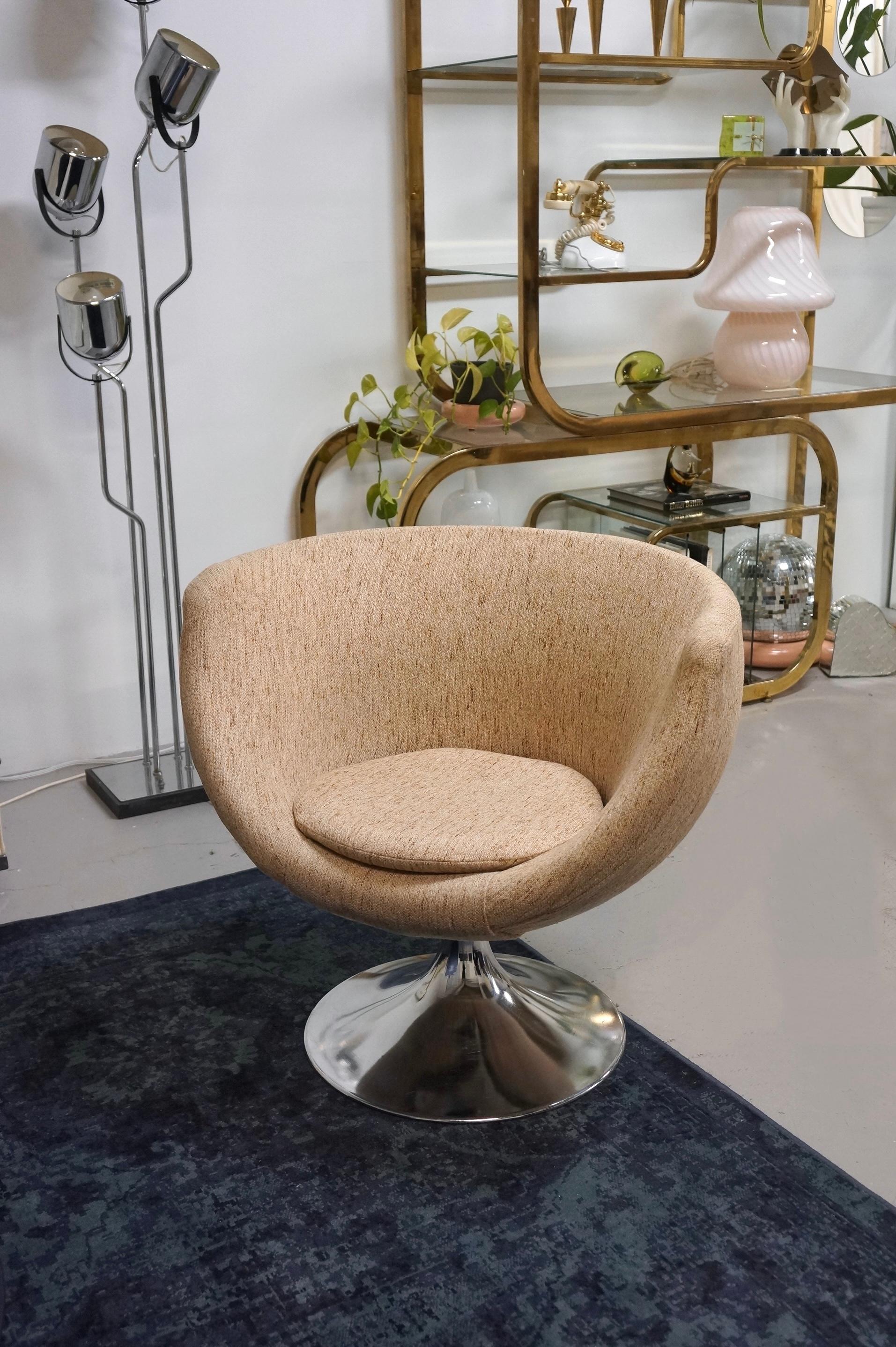 Un superbe fauteuil pivotant pod en tissu tweed et base chromée. Cette chaise longue spectaculaire est attribuée à Overman et a été fabriquée dans les années 1960. Le tissu est en tweed et dans des tons chauds et neutres. La base est en aluminium