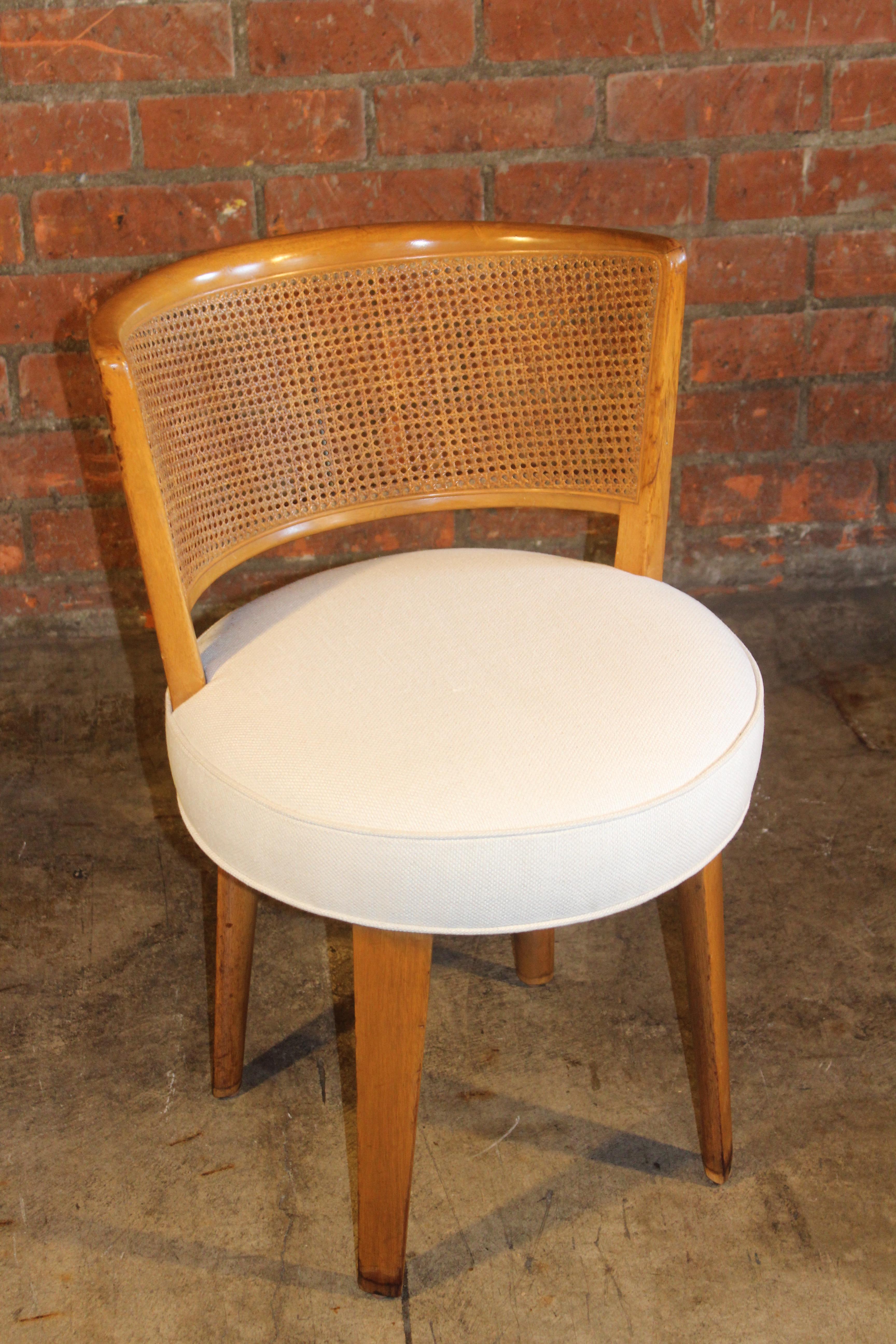 A vintage 1950s swiveling vanity chair designed by Edward Wormley for Dunbar. Completely restored. Newly refinished, new caning and new upholstery in an off-white Belgian linen. Overall wonderful condition.