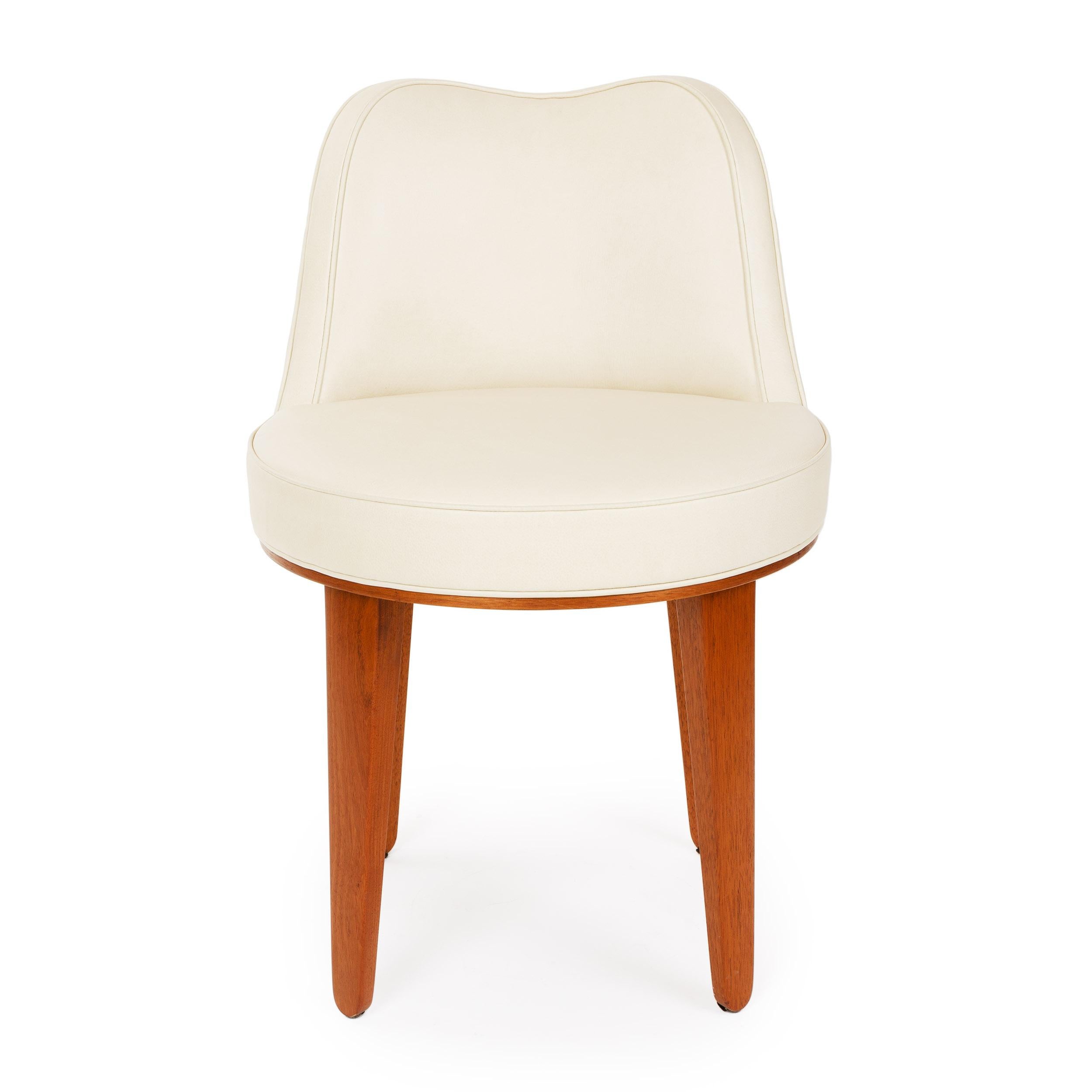 A small sway backed swivel chair with hairpin tapered natural mahogany legs. Newly reupholstered in putty leather.