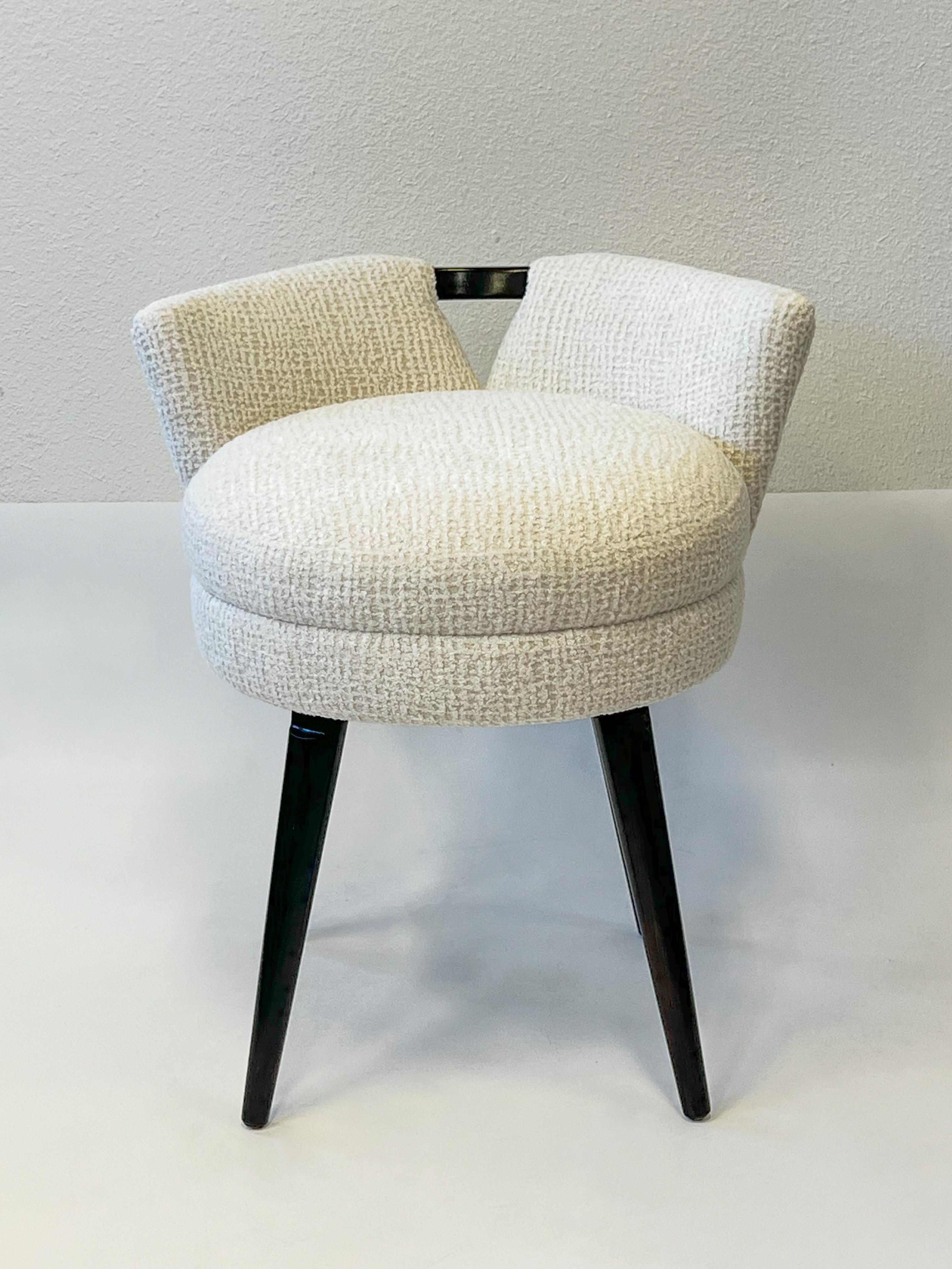 Tabouret de vanité pivotant en noyer foncé des années 1950 par Paul Frankl. 
Nouvellement tapissé d'un tissu velouté blanc cassé. Le bois a été refini. 
Pivotement à 360°. 

Dimensions : 20