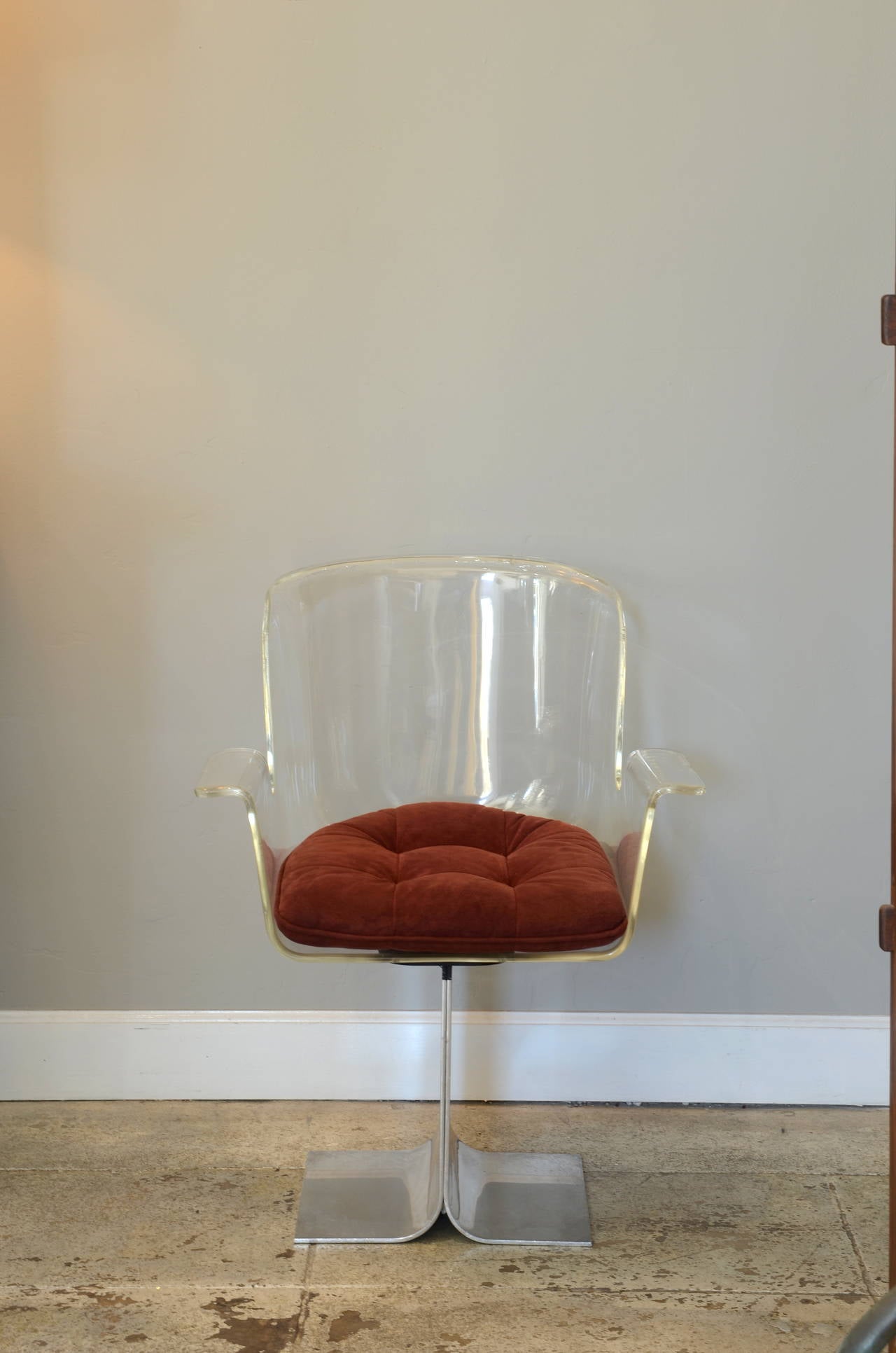 Swiveling Lucite and polished aluminum armchair by Irving Rosen for Pace Collection. Crimson velvet upholstered cushion.

Measures: Arm height 24.5