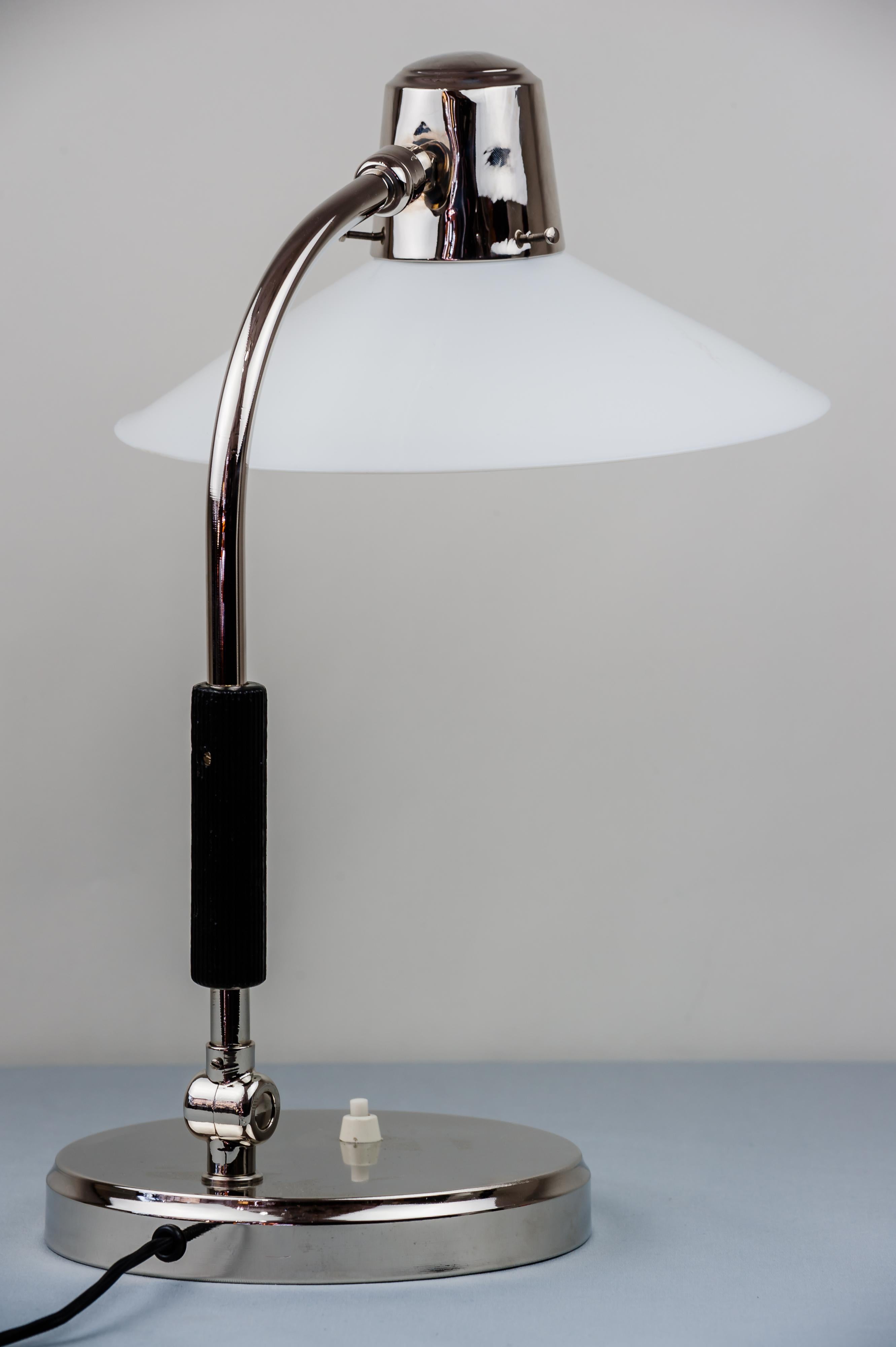Swiveling nickel table lamp around 1920s with original glass
Wood handle.