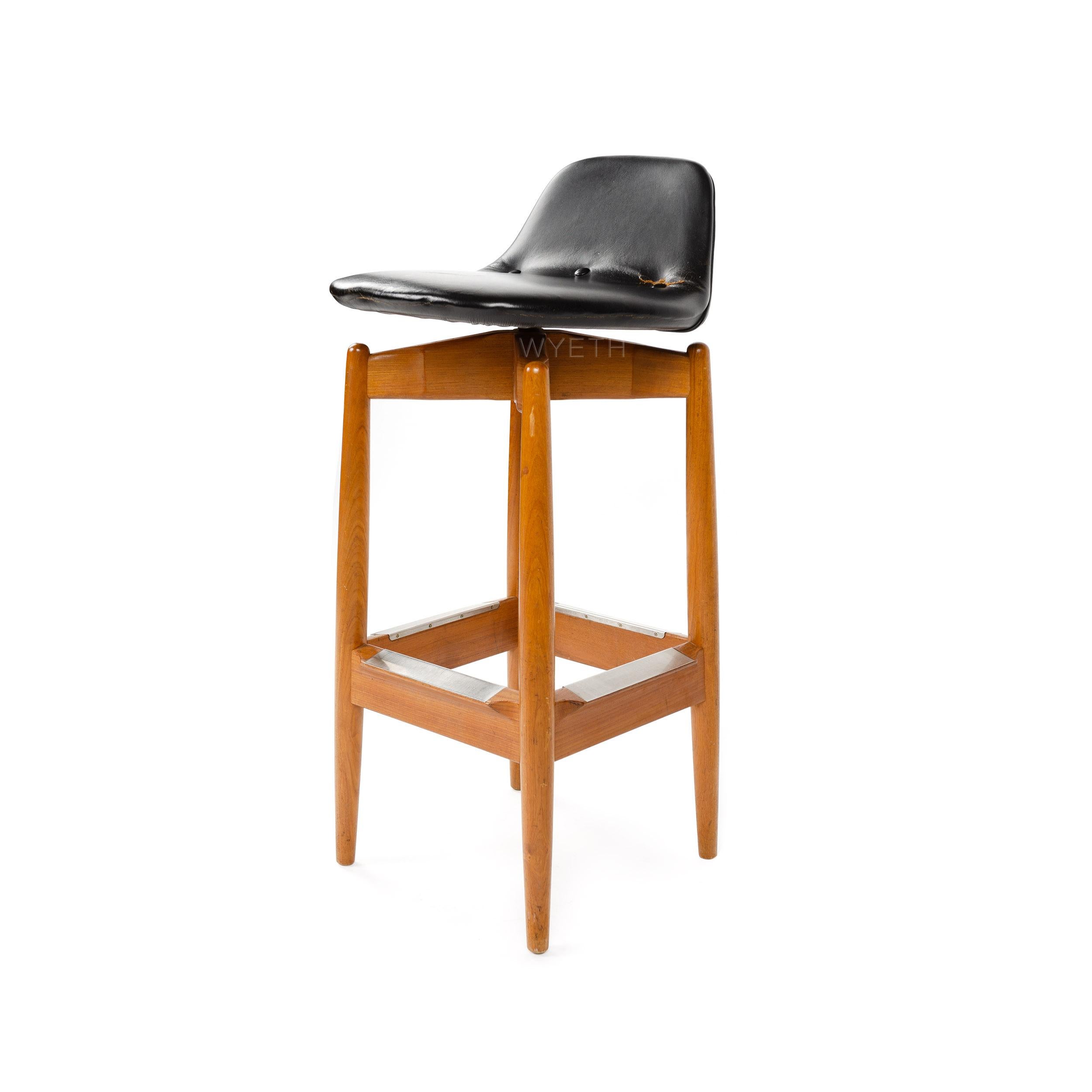 A teak barstool with a leather swivel seat.