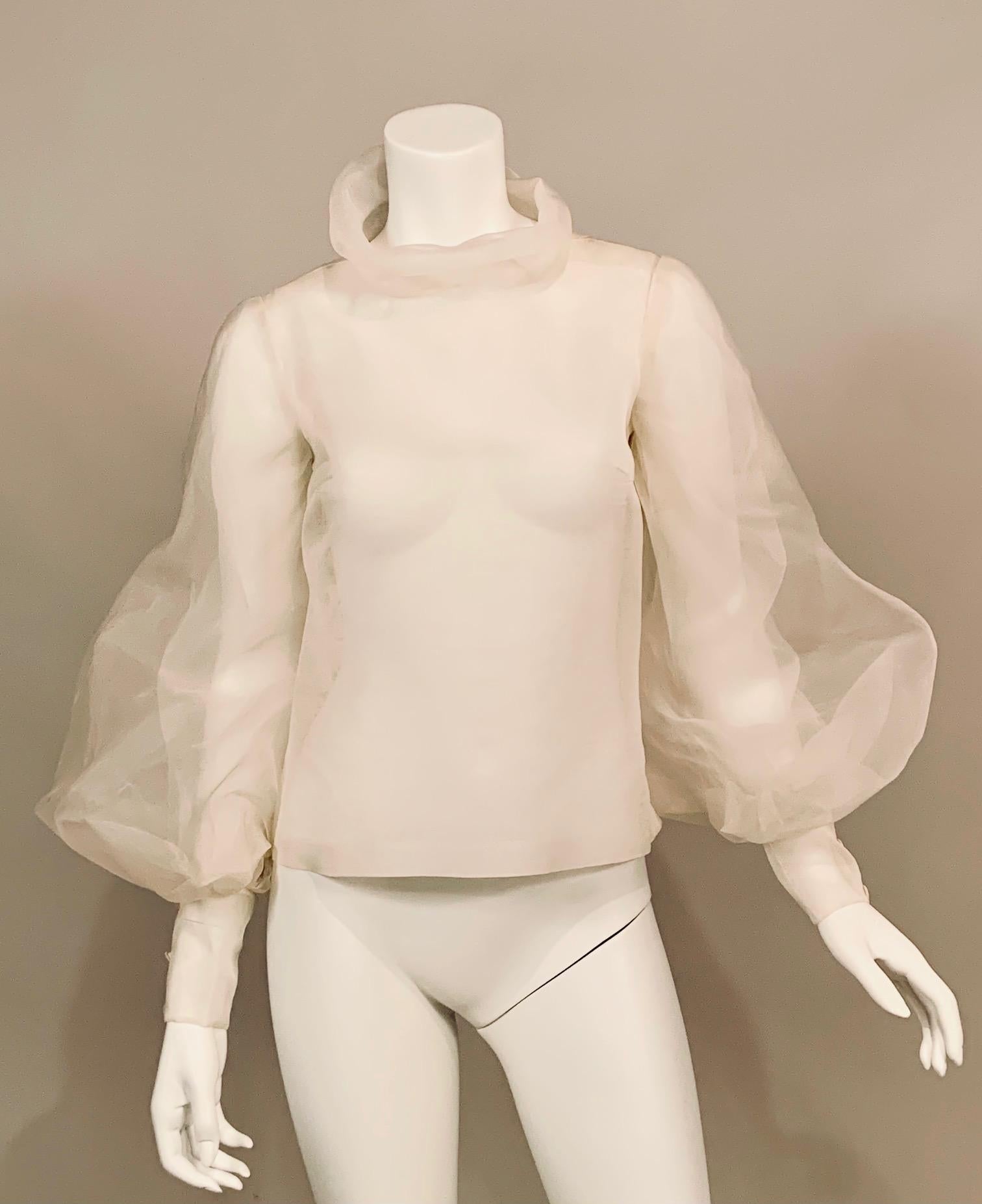 This Sybil Connolly sheer silk organza blouse is made from two layers of fabric in the Couture manner with generous amounts of hand sewing. The blouse has a stand up or rolled collar, long fitted sleeves with a very full, almost billowing second