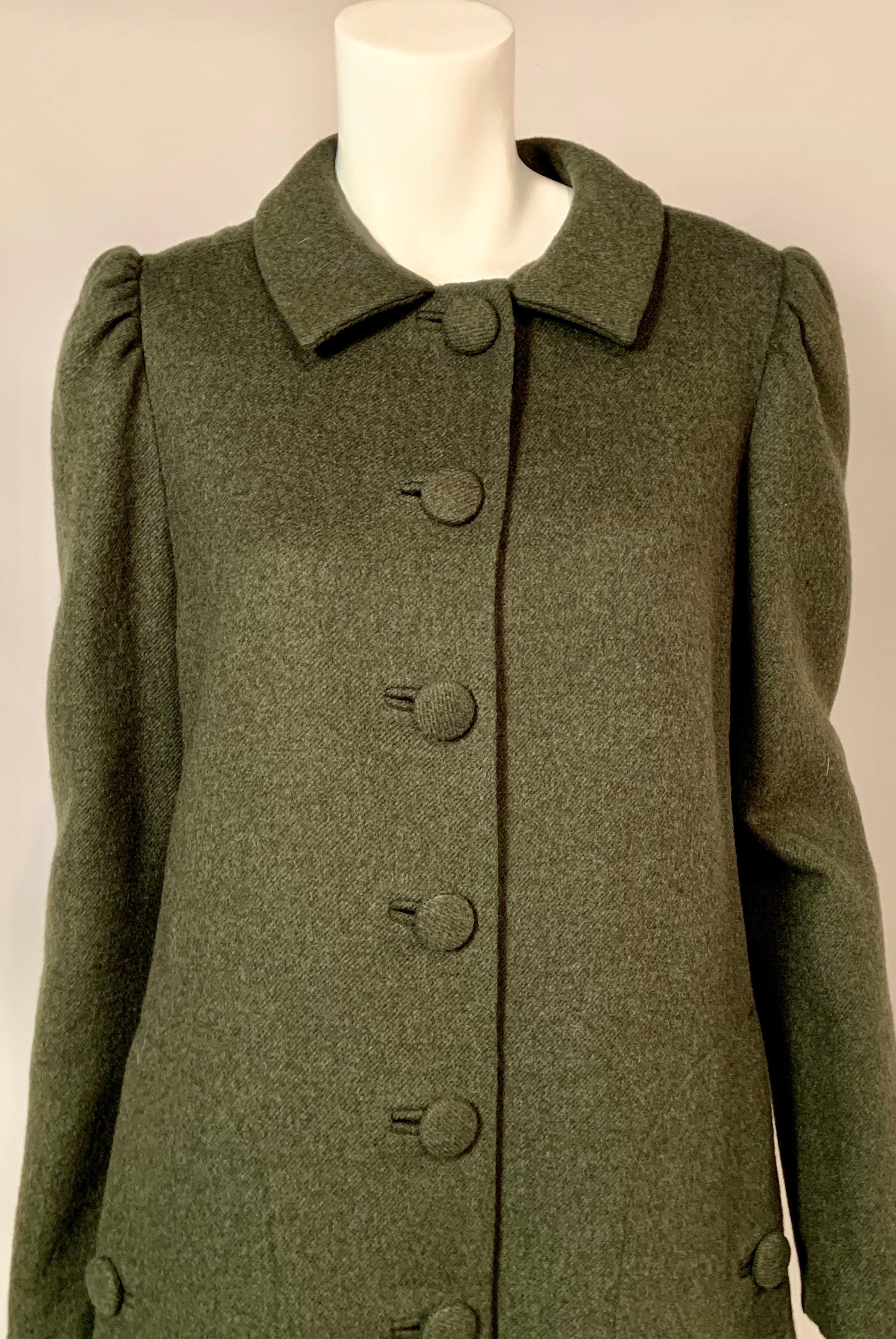 Sybil Connolly is known as the Irish Couturier, and was well known for using Irish made fabrics in her garments.  She is most famous for designing the dress Jackie Kennedy is wearing in her official White House portrait.  
This loden green wool coat