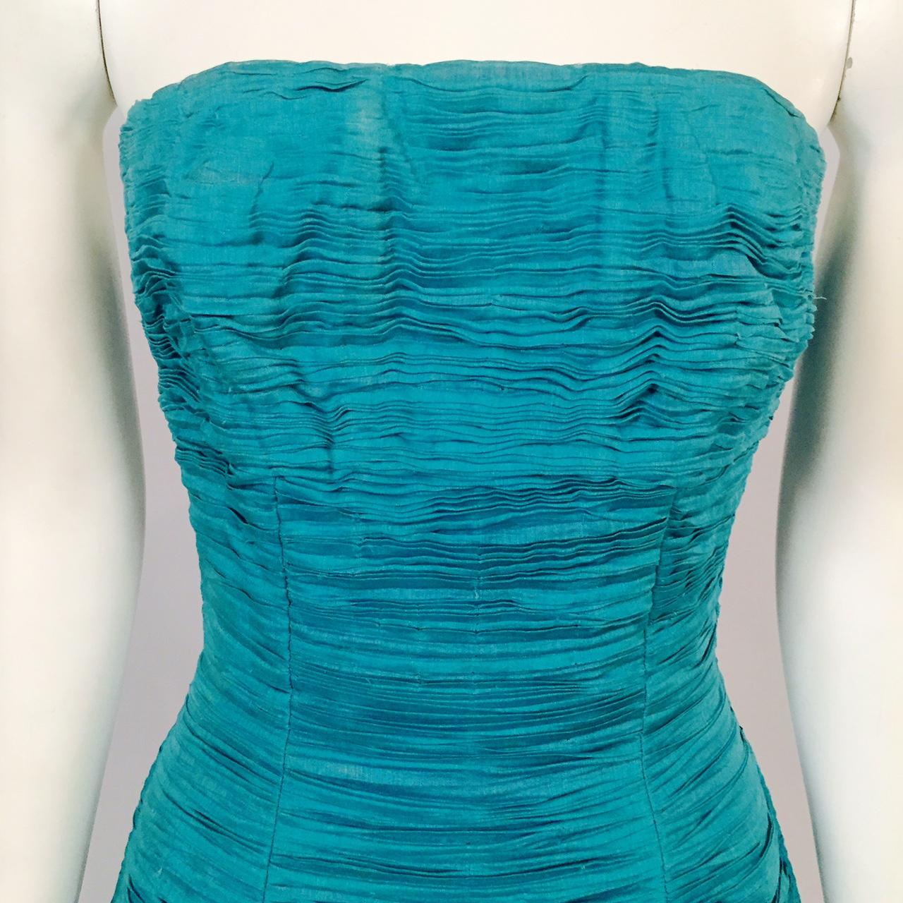 Sybil Connolly, the Irish Couturier,  is most famous for her extremely rare pleated linen clothing. Each garment used nine yards of linen to make one yard of pleated linen. This stunning blue/green linen evening gown was designed and made in the