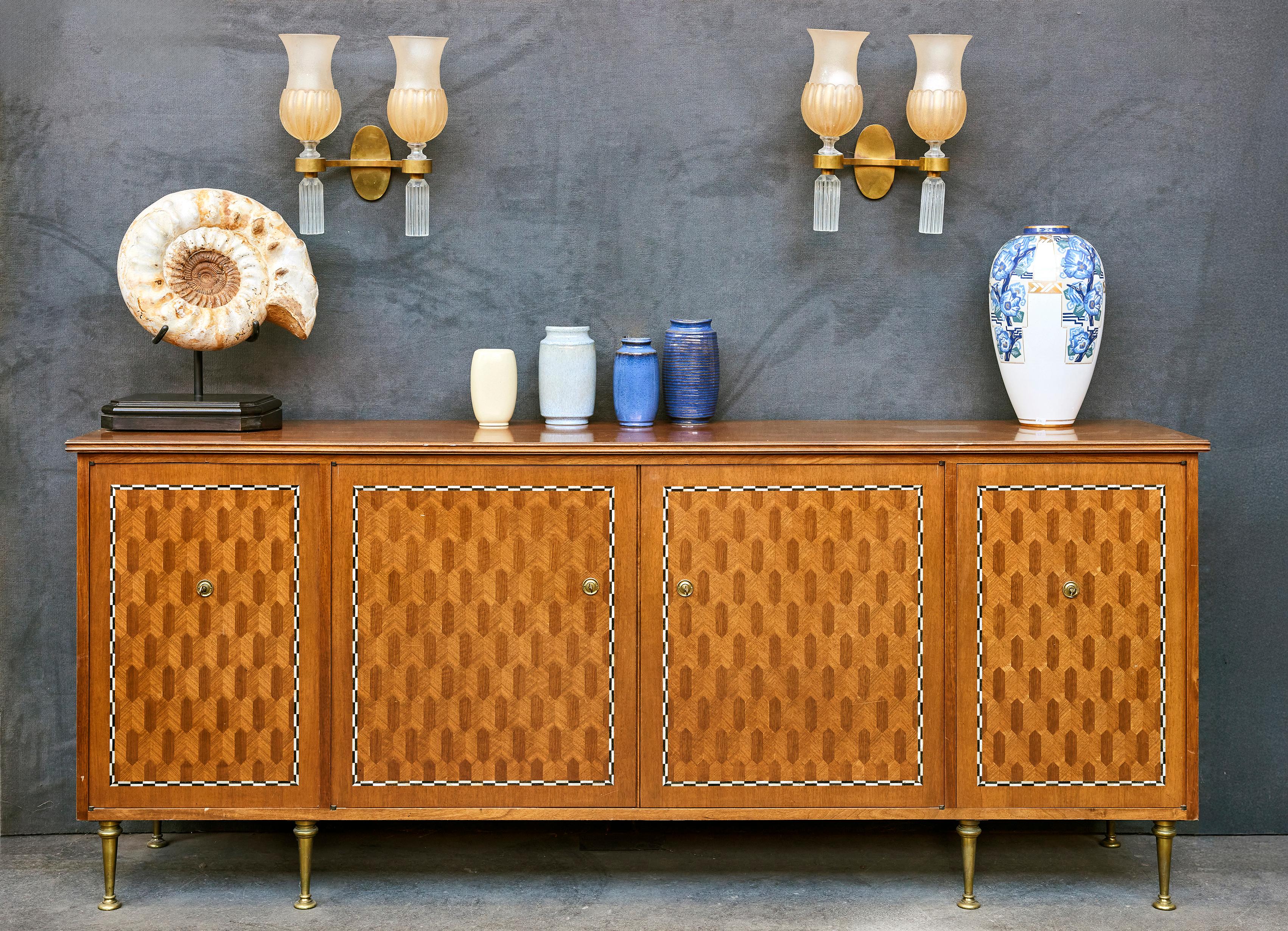 JULES LELEU (1883-1961)
Sycamore veneer sideboard inlaid with mother-of-pearl plaques,
with a quadrangular body opening with four solid doors adorned with marquetry.
Ovoid-shaped gilt bronze base with parallel legs.
(Small veneer chips and