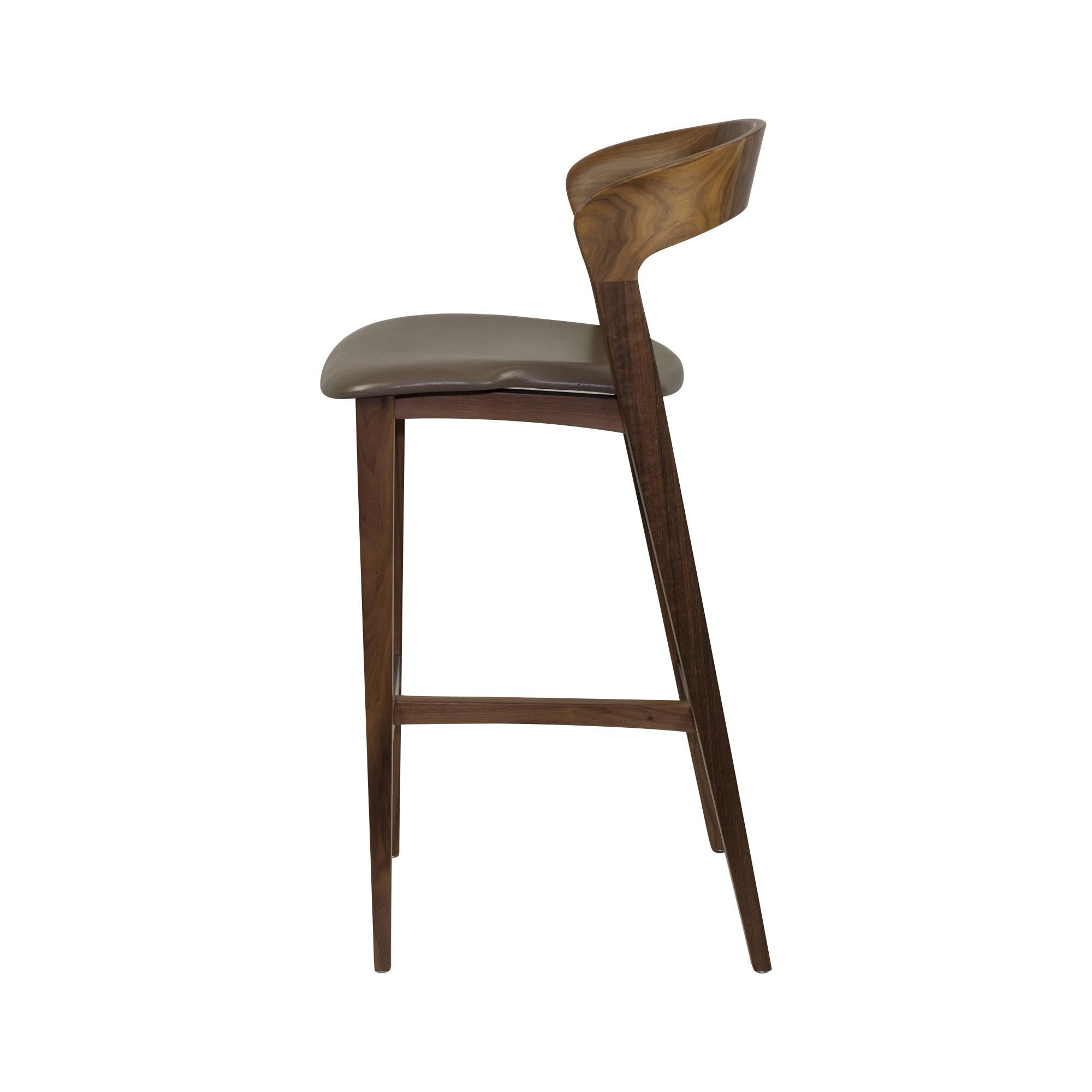Bar stool with elegantly curved back and tapered legs in shown in solid walnut with a leather seat.
Available in counter or bar height. Available in other woods, stain colors, COM fabric and leathers.