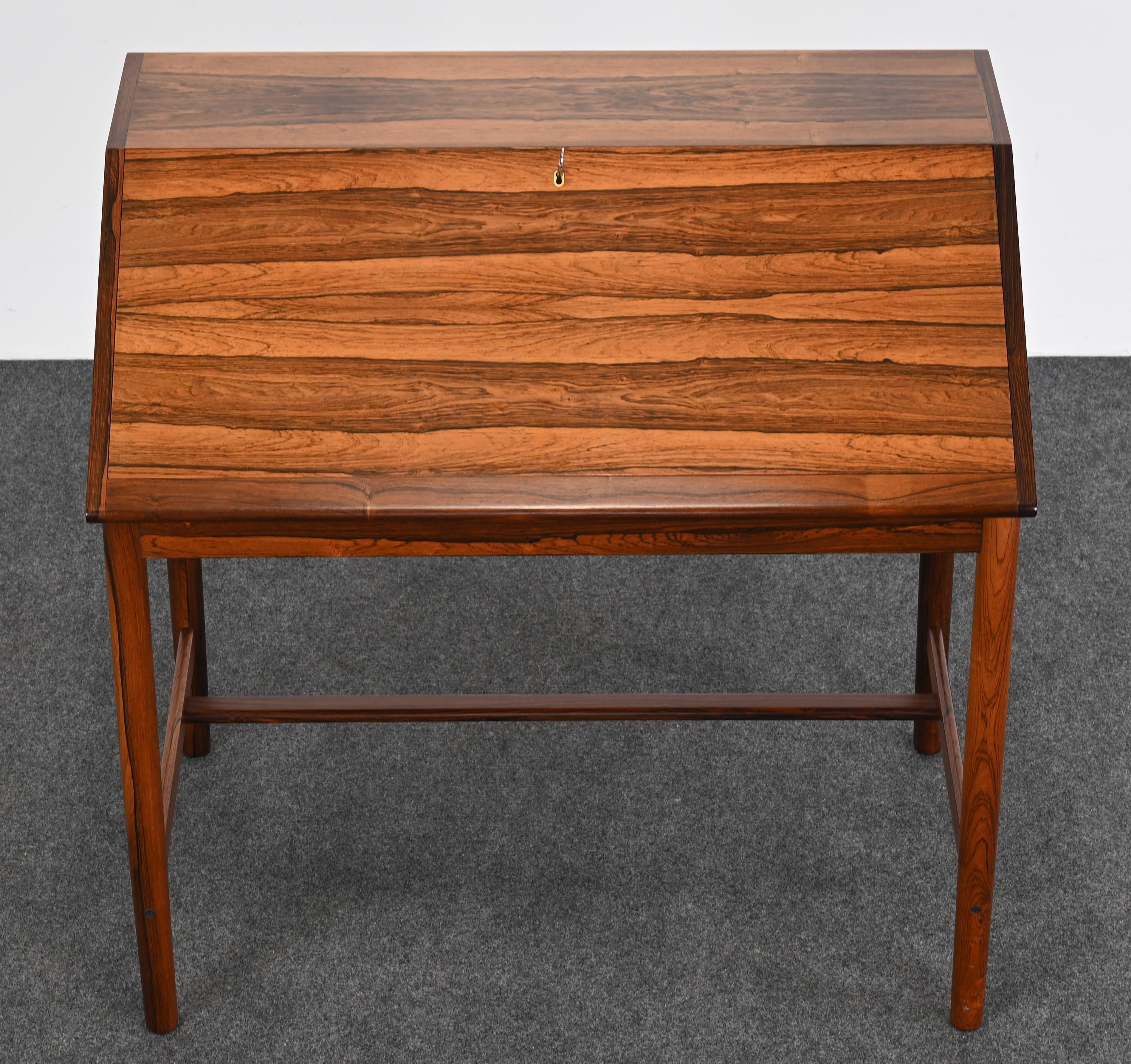 A stunning and very beautiful Rosewood Desk for Brode Blindheim by Sykky Iven circa 1960s. This amazing slant front desk is structured on a refined stretcher base. The cabinet has wonderful rosewood graining with warm amber tones. The interior is