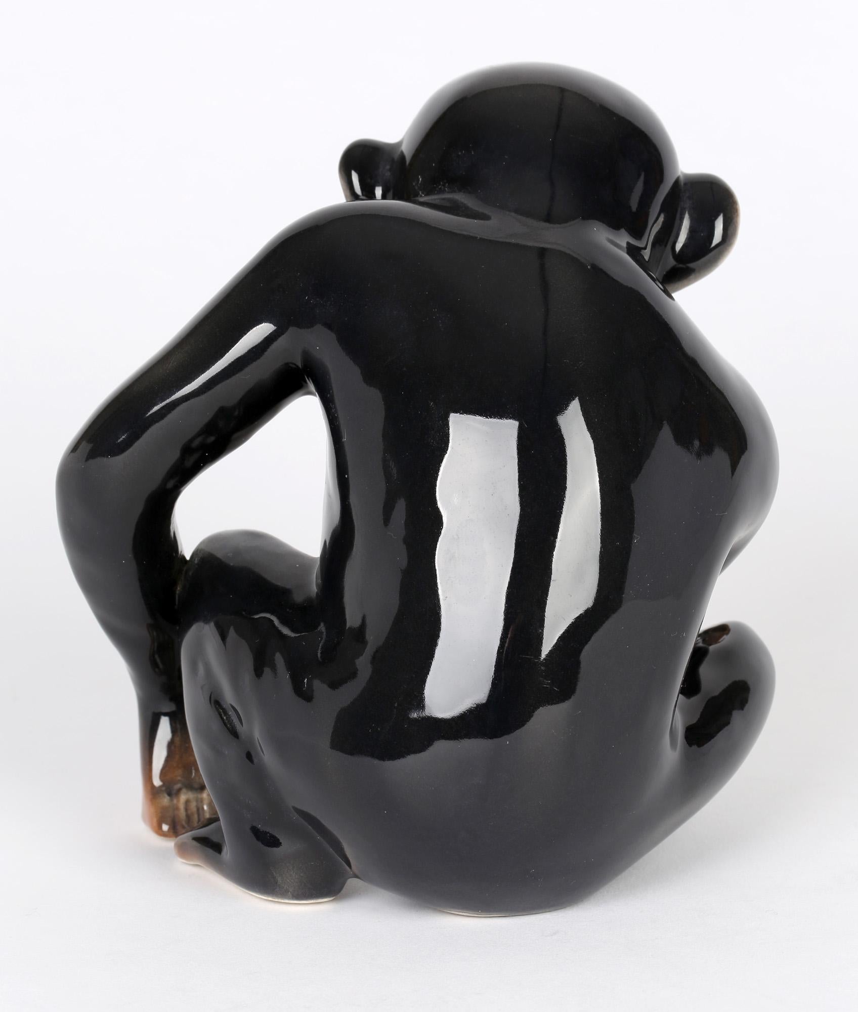 A charming and well modeled Art Deco pottery of a chimpanzee made in England by Sylvac and dating from around 1940/50. The chimpanzee sits on its hind legs and holds a carrot in one hand while resting the other on the ground and appears to be