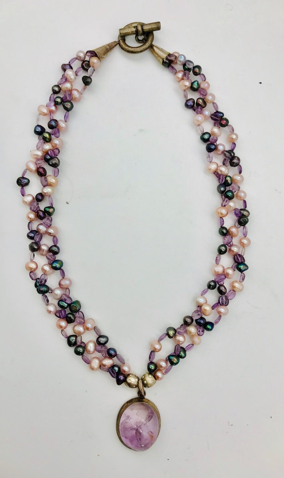 Amethyst Pendant and Beads with pink and black pearls in 3 strand braided Necklace with a large Amethyst Pendant., and silver plated clasp.
 Pearls are the only gems created by an oyster – a living organism. Today, most pearls are grown on