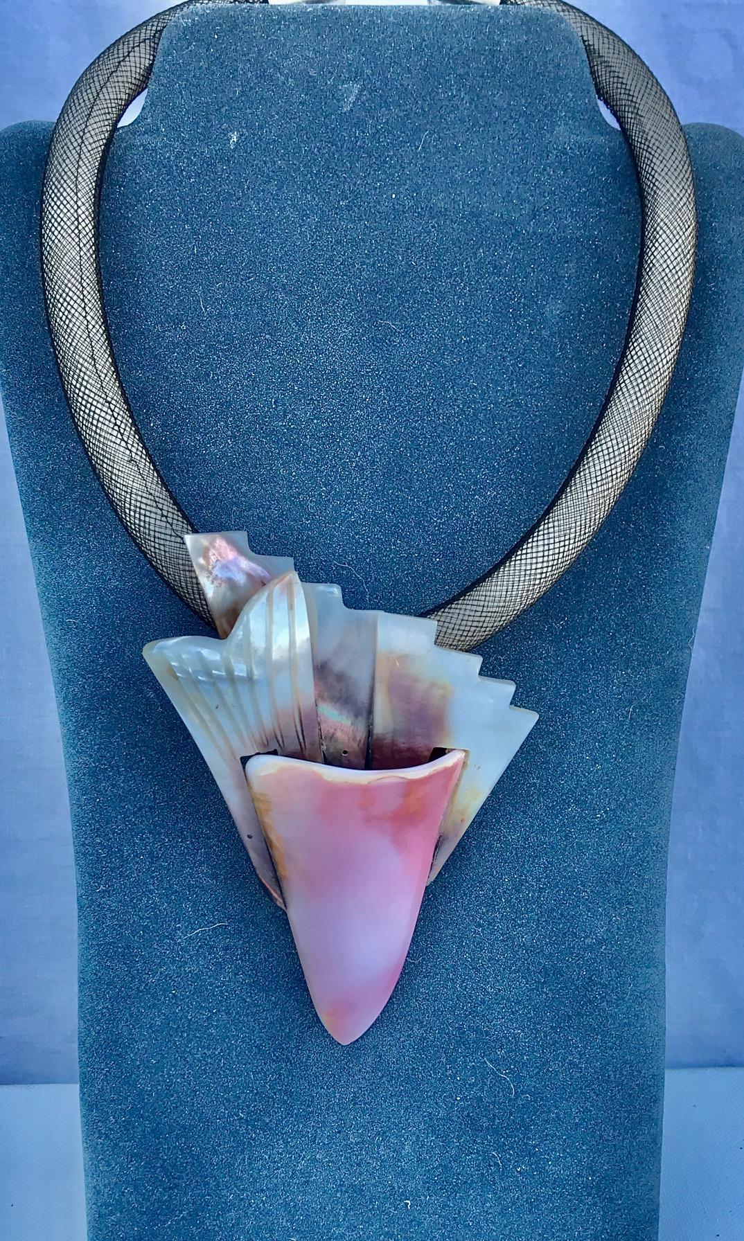 This exceptional Conch and French Deco Wild black mother of pearl  Pendant is composed from 3 Deco objects as a background for a Conch triangle. The necklace is rubber with nylon mesh and silver plated clasp.

Pink Conch shell can be seen in a photo